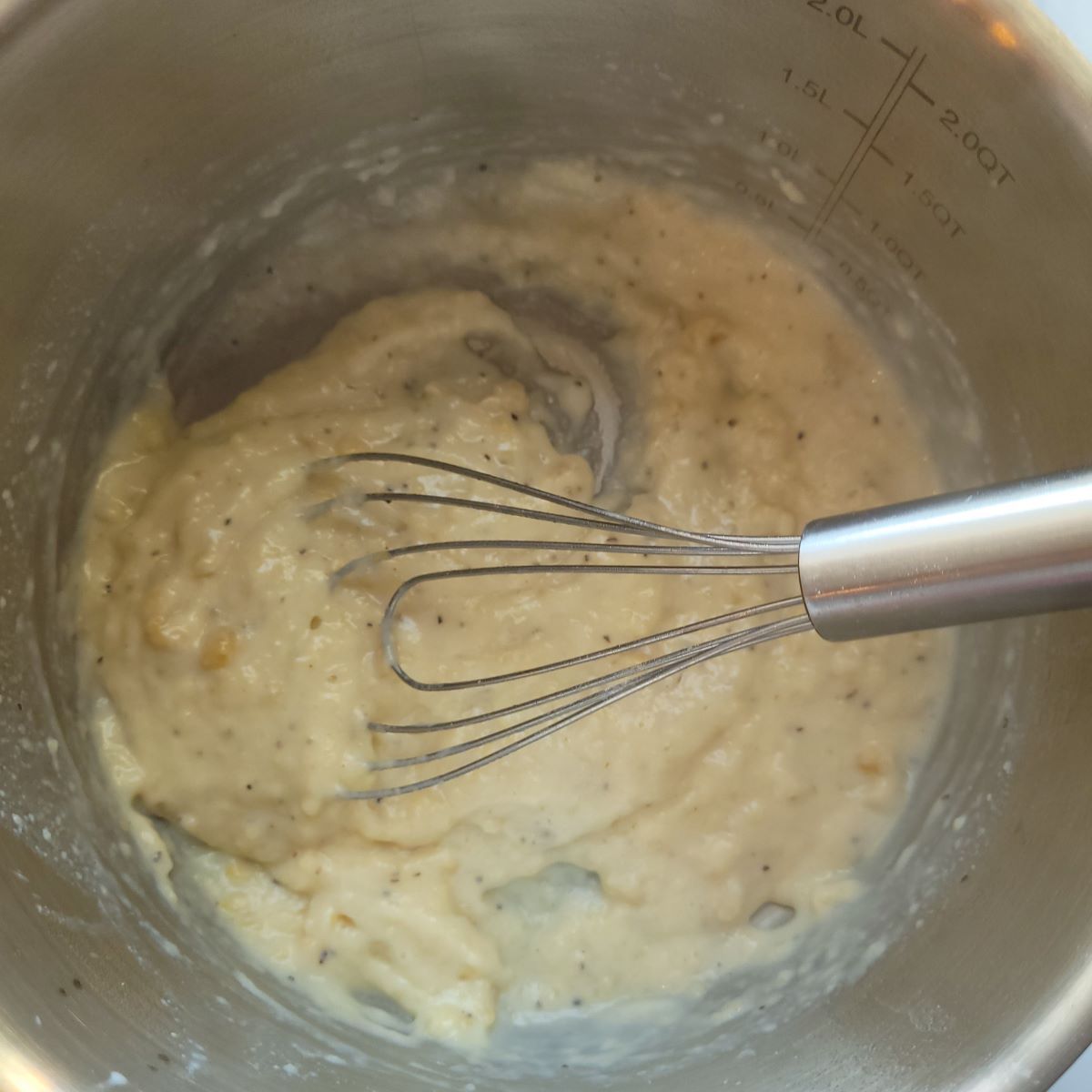 Flour, oil, and milk whisked together in a medium saucepan.