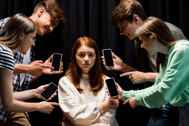 holding smartphones with blank screen on black