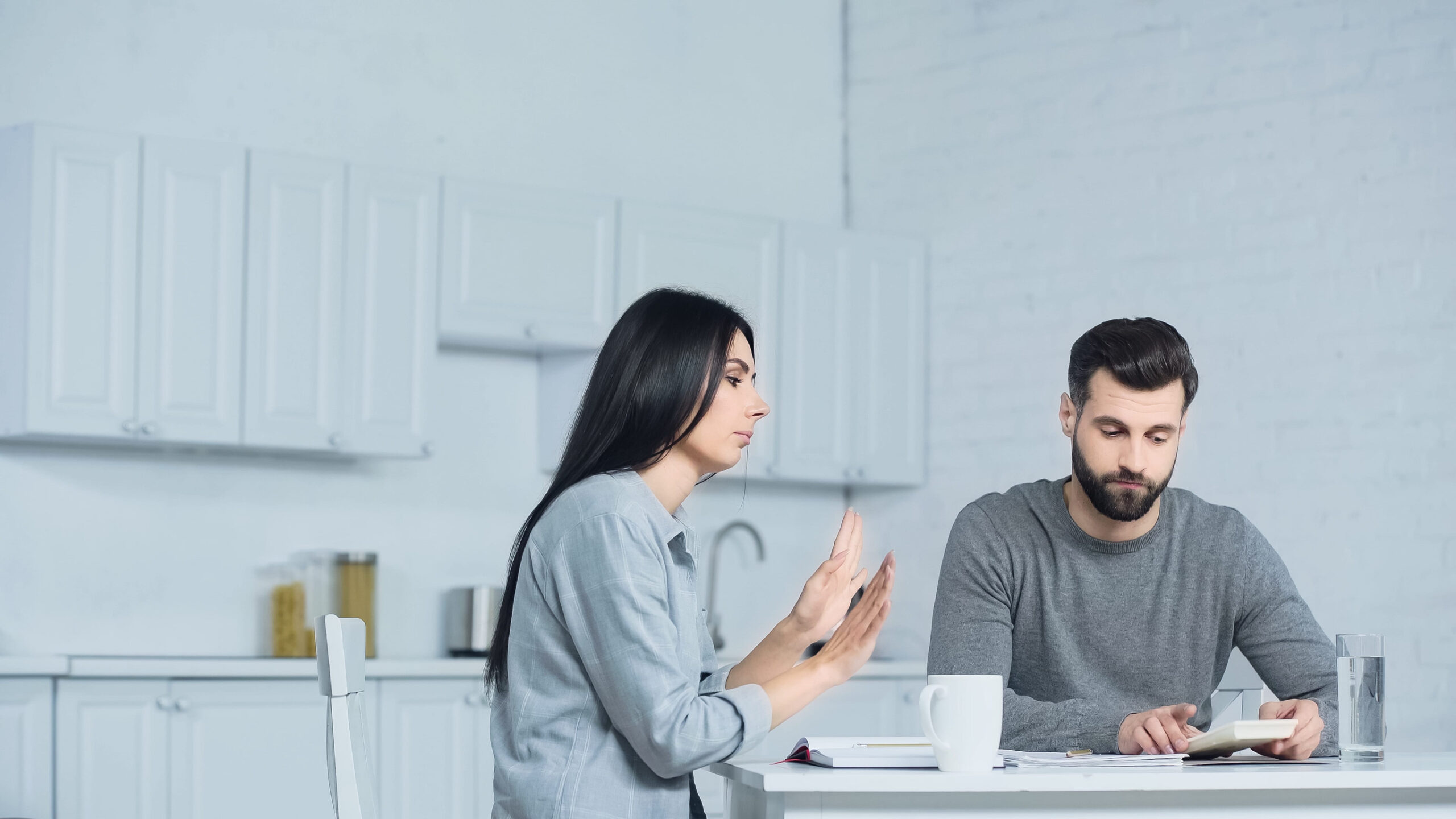 displeased woman gesturing near man with calculator