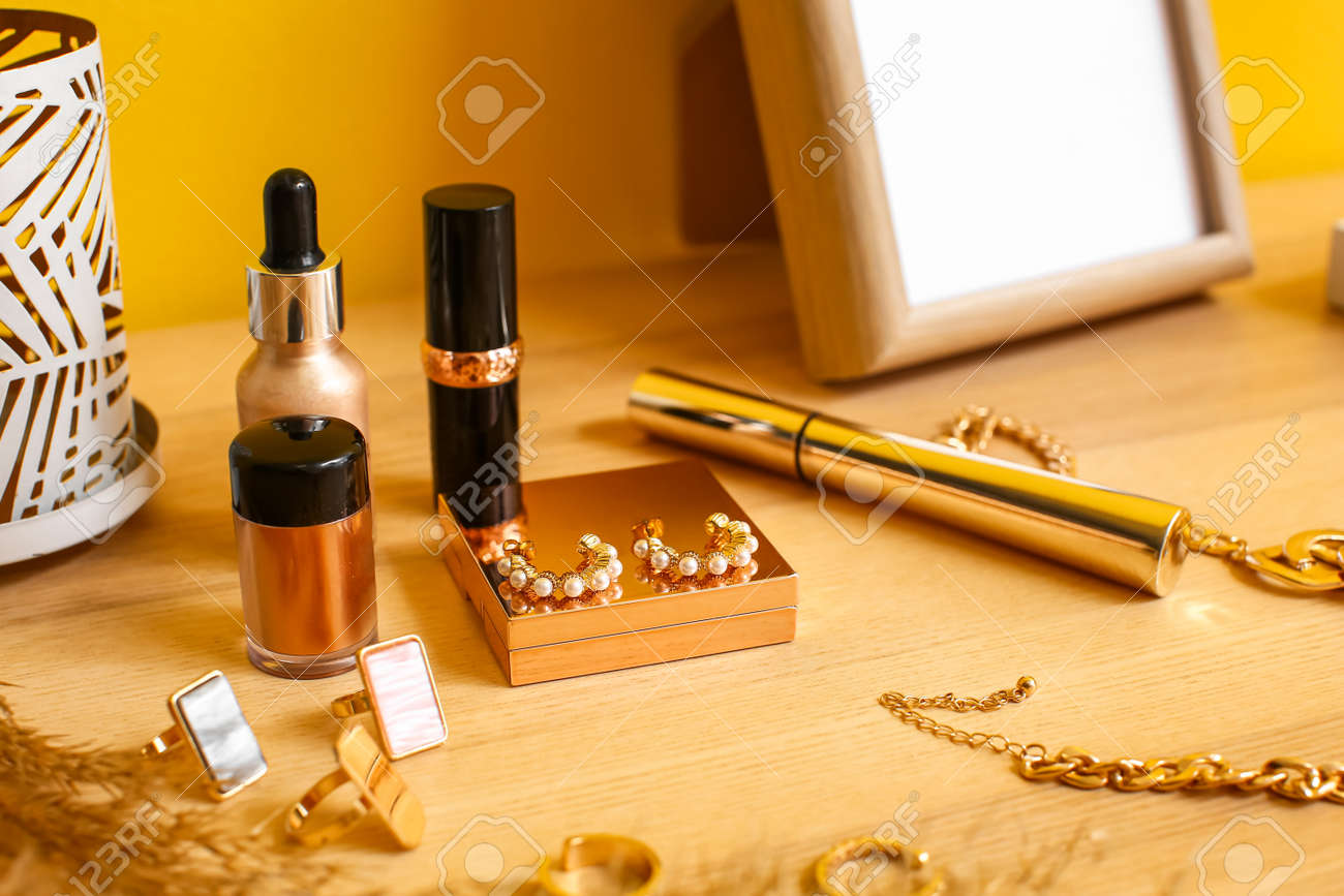Beautiful jewelery and cosmetics on wooden table
