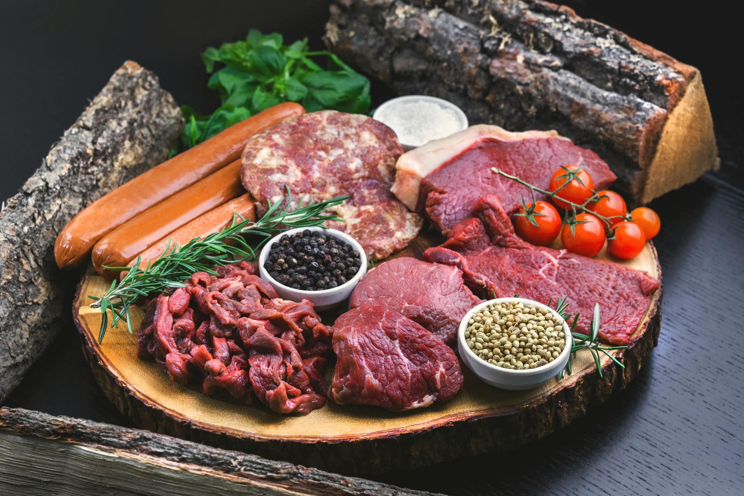 A beautifully arranged platter of raw meats and fresh herbs, perfect for cooking enthusiasts.