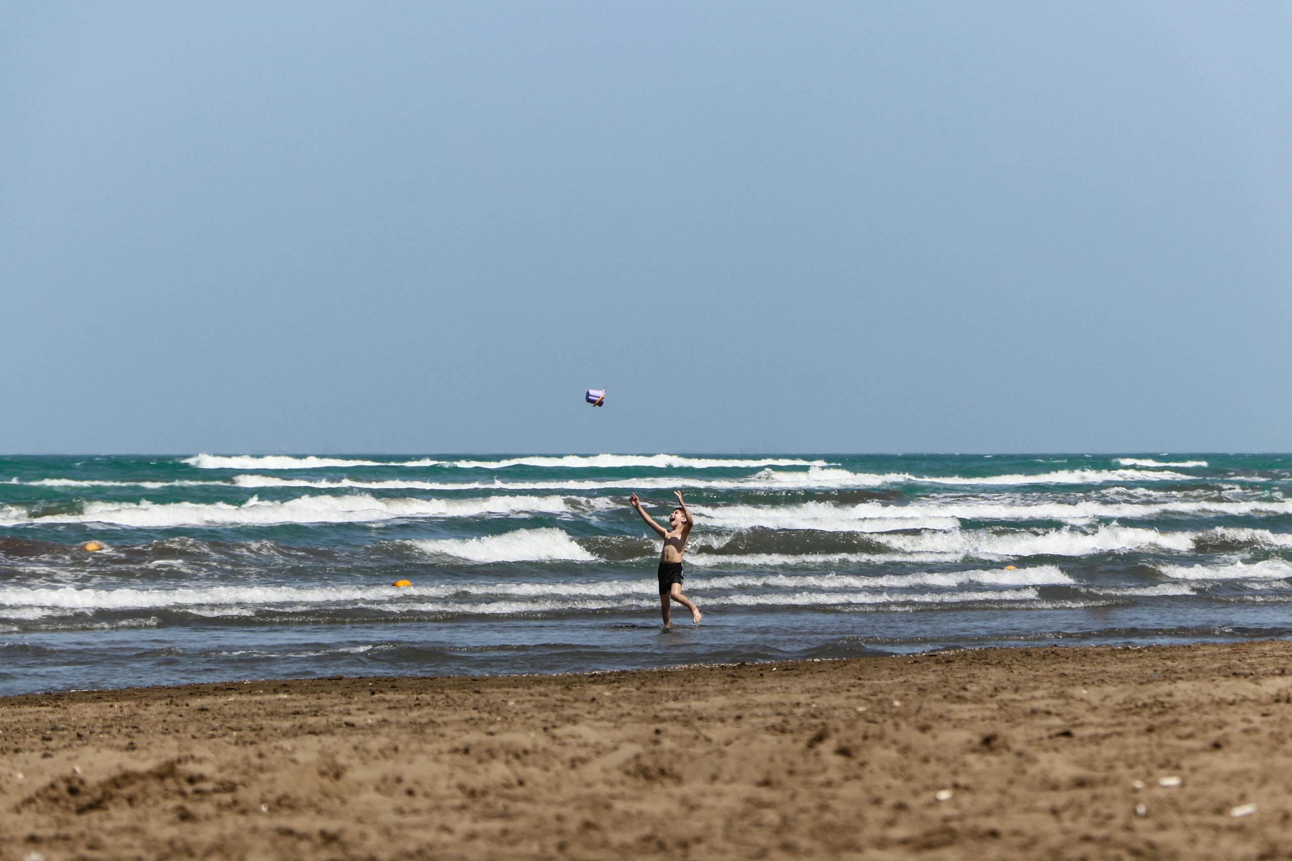 A child enjoying a summer day, playing with a kite on a beach in Baku, Azerbaijan.