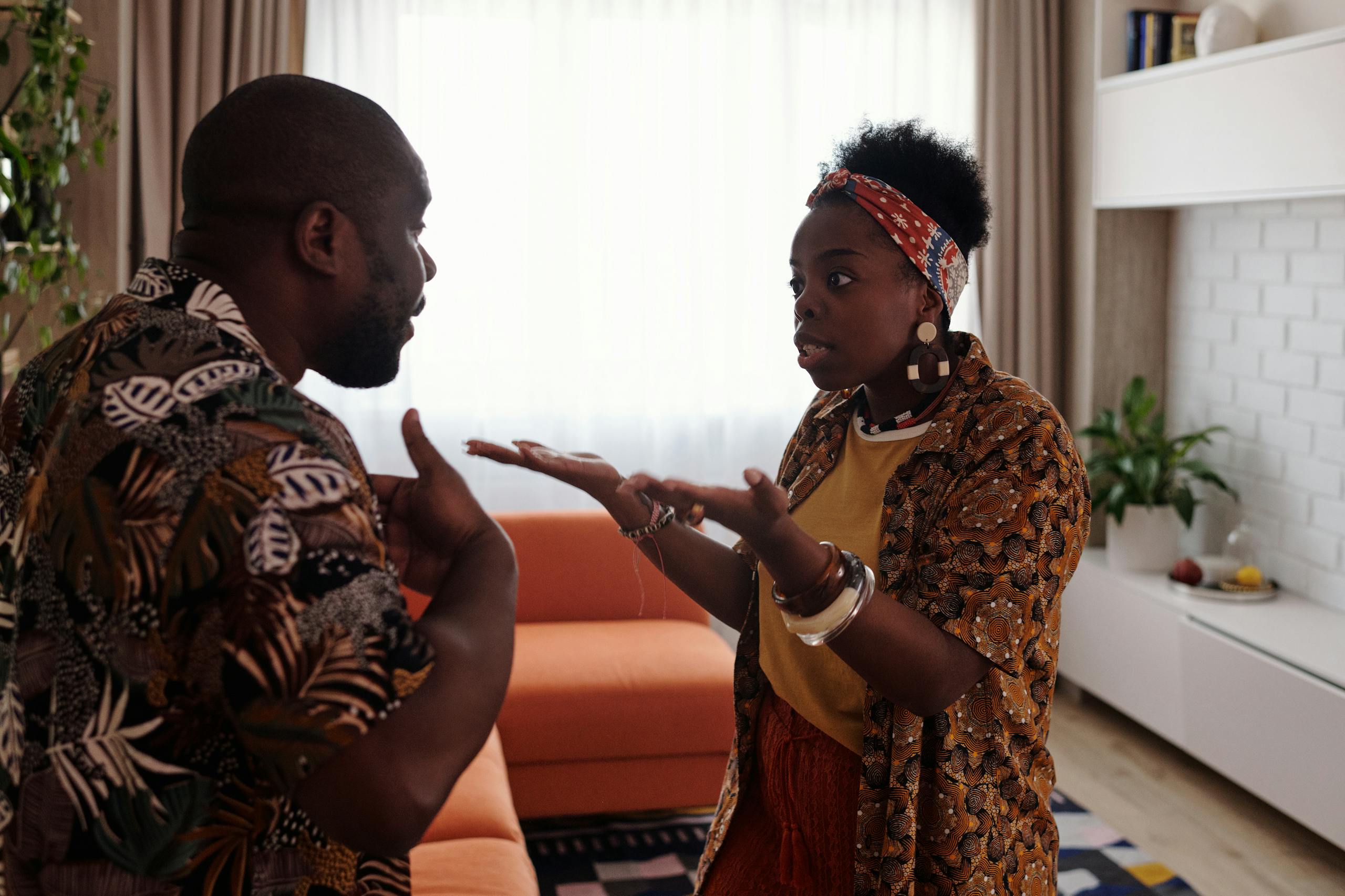 A couple arguing passionately in their living room, expressing emotions and gestures.