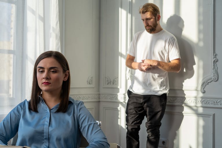 A couple struggles with emotional tension during a counseling session.