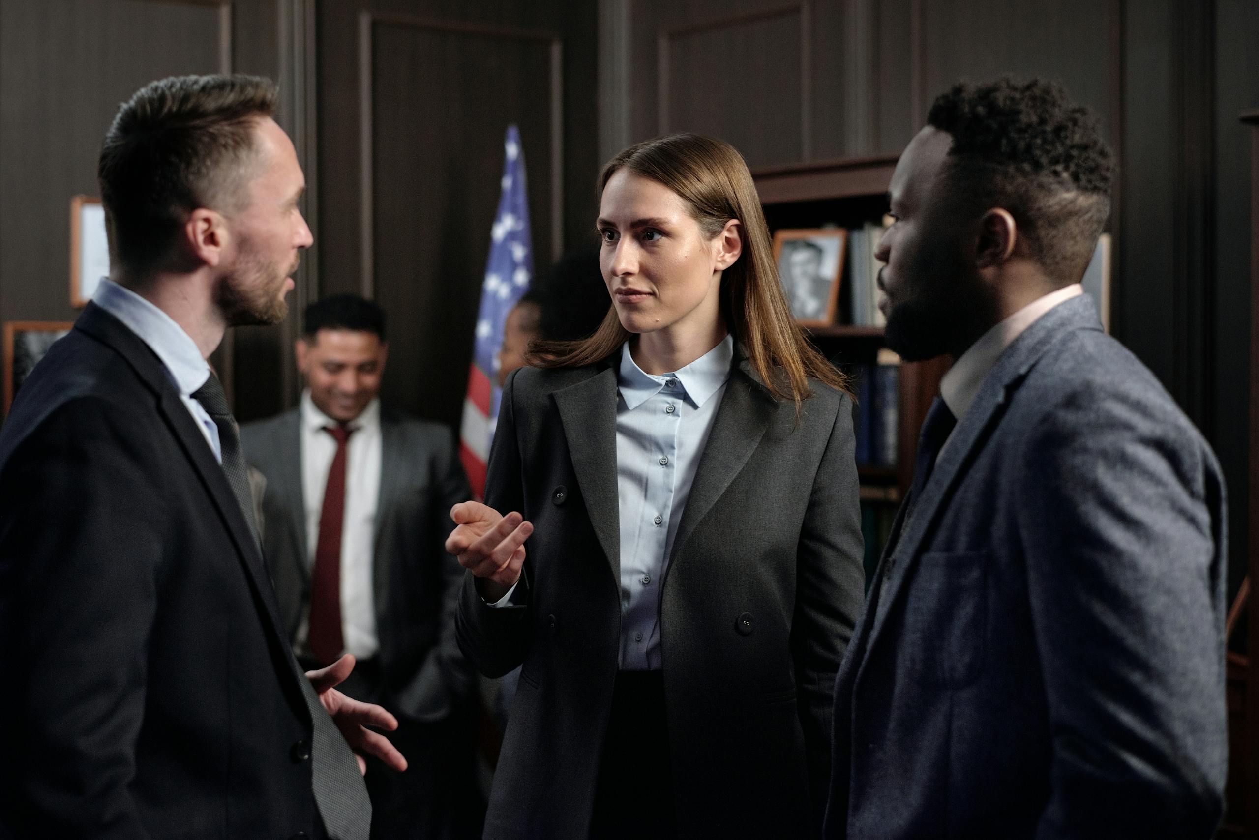A diverse group of business professionals engaged in a discussion in an office.