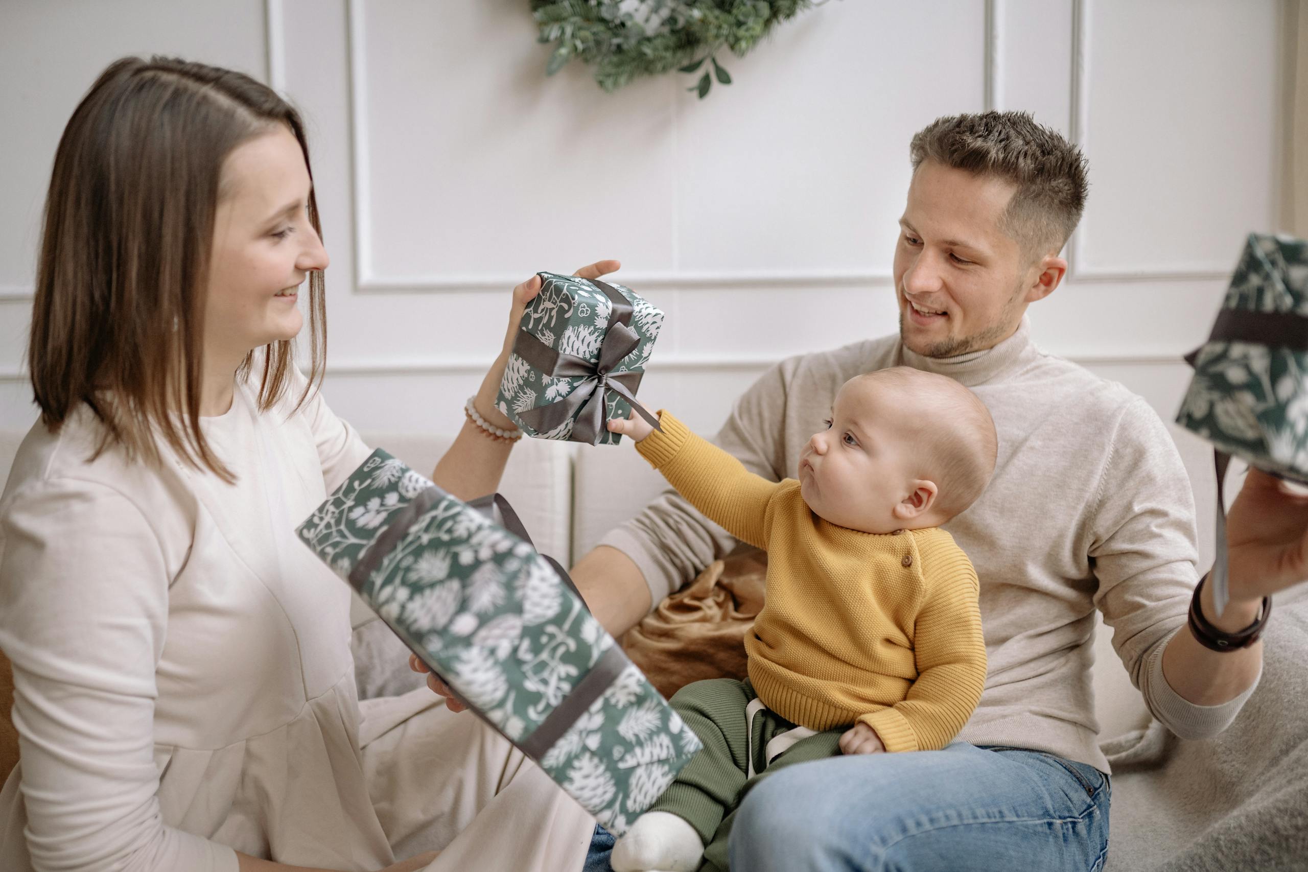 A joyful family exchanging Christmas presents while bonding indoors.