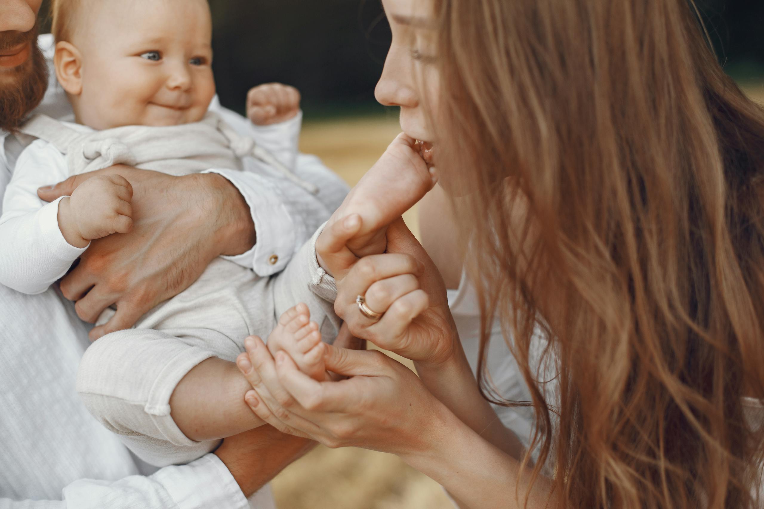 A loving family interaction with a baby and mother in an outdoor setting, showing warmth and connection.