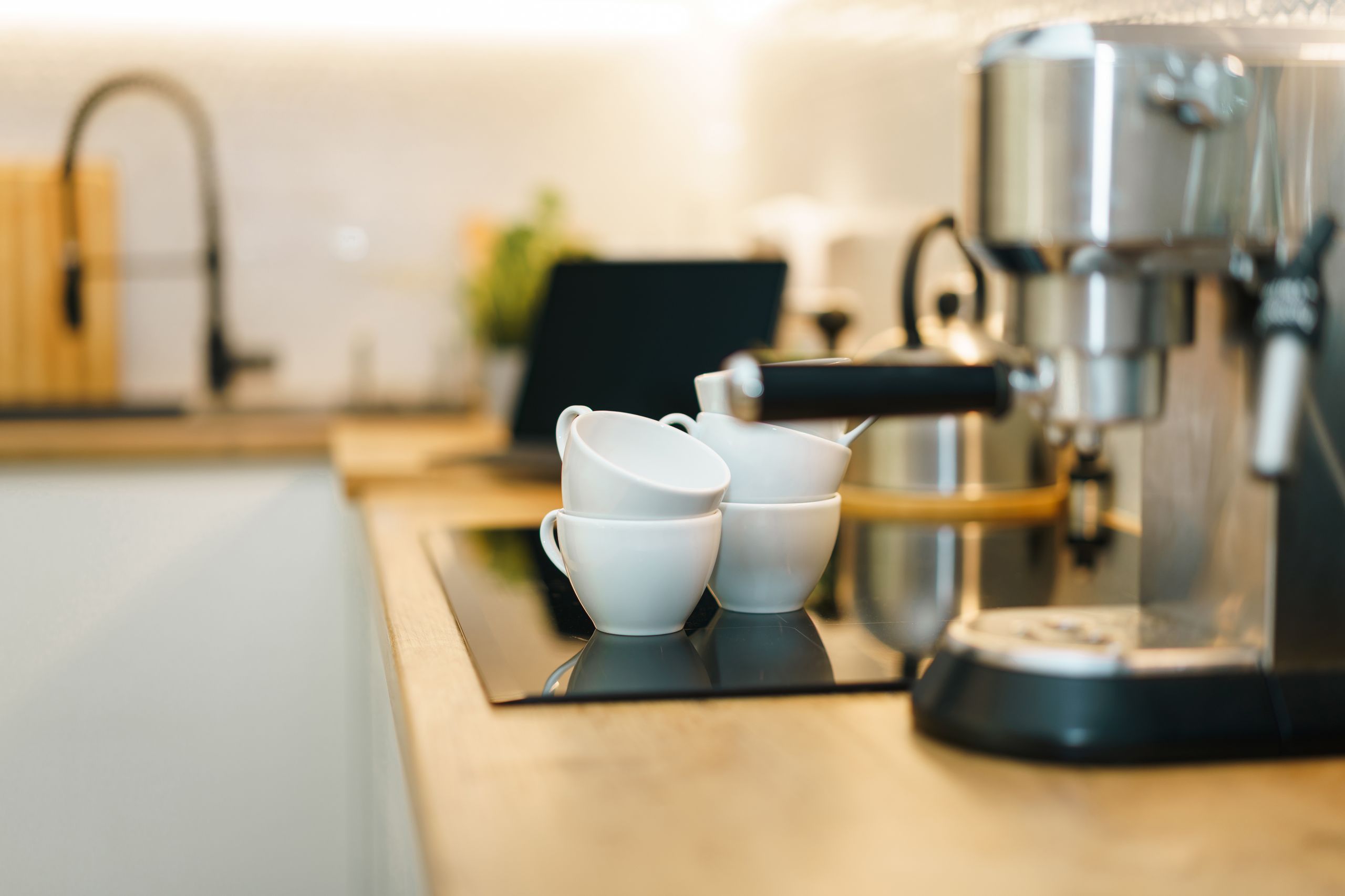 A modern espresso machine with coffee cups on a kitchen counter, showcasing a cozy and inviting setup.