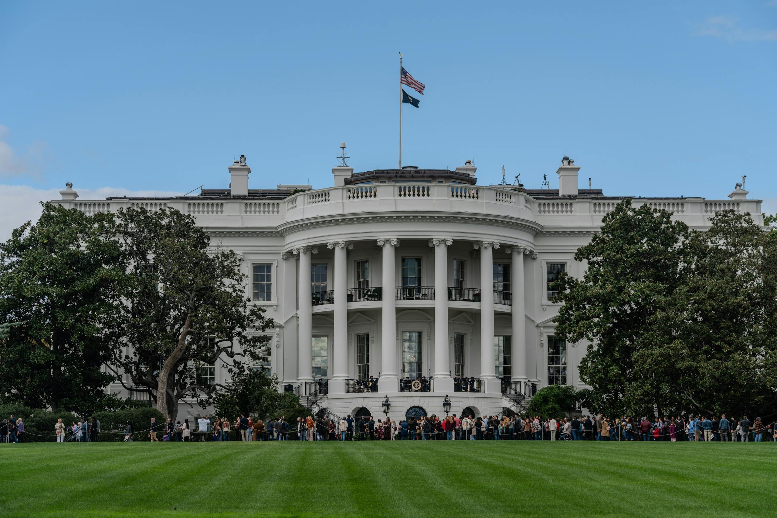 A picturesque view of the White House with the American flag in daylight.