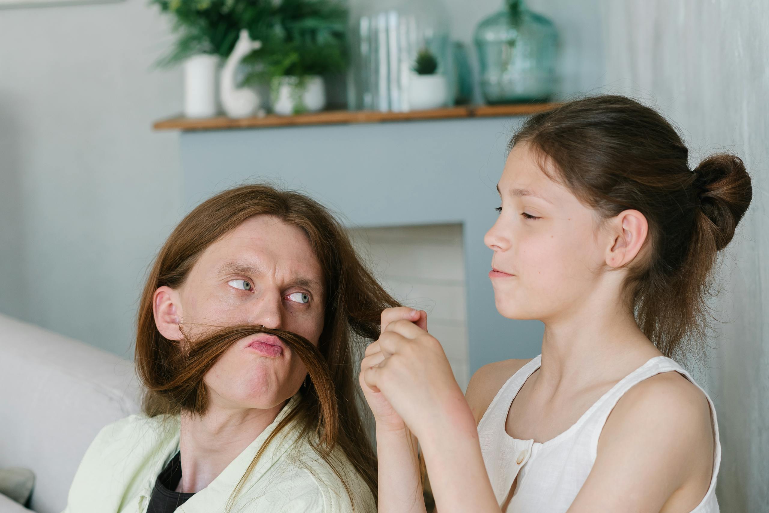 A playful indoor scene showing a fun interaction between a man and a girl.