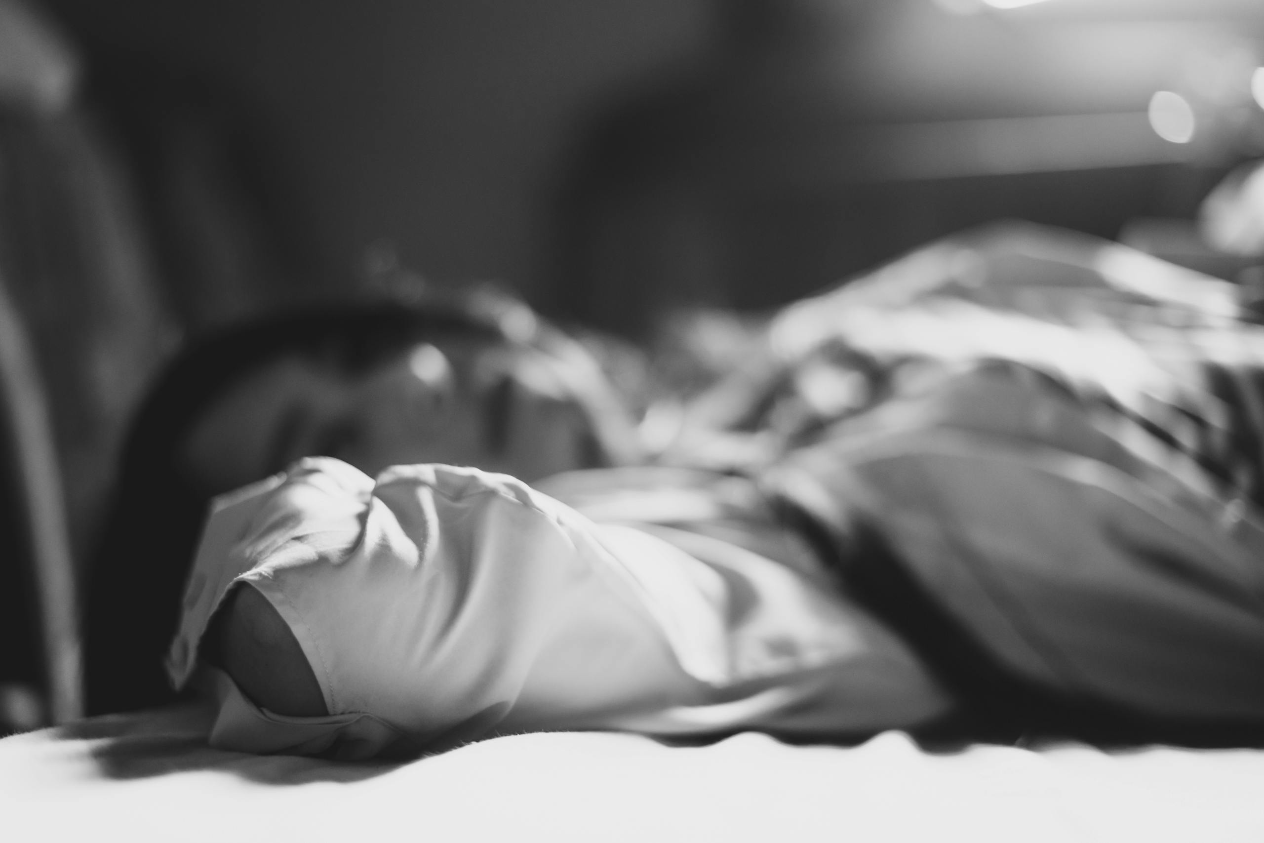 A serene black and white portrait of a woman lying down, evoking calmness.