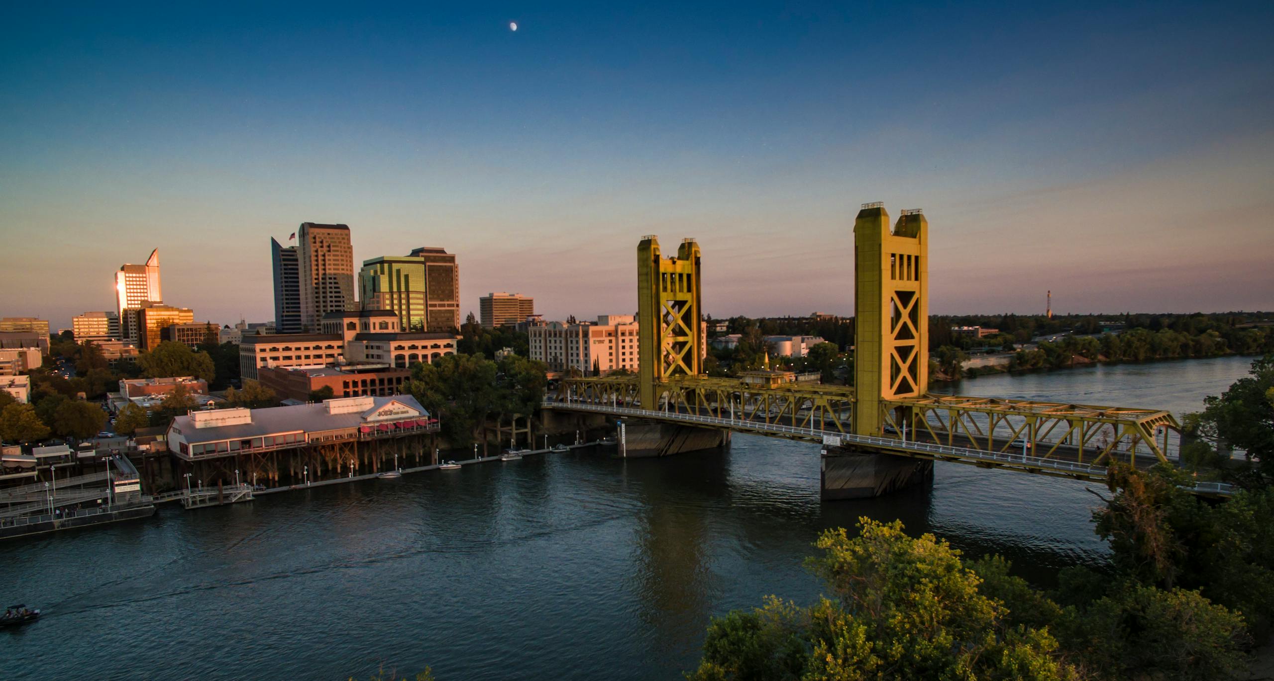 A stunning sunset view of Sacramento's iconic Tower Bridge with the city skyline in the backdrop.