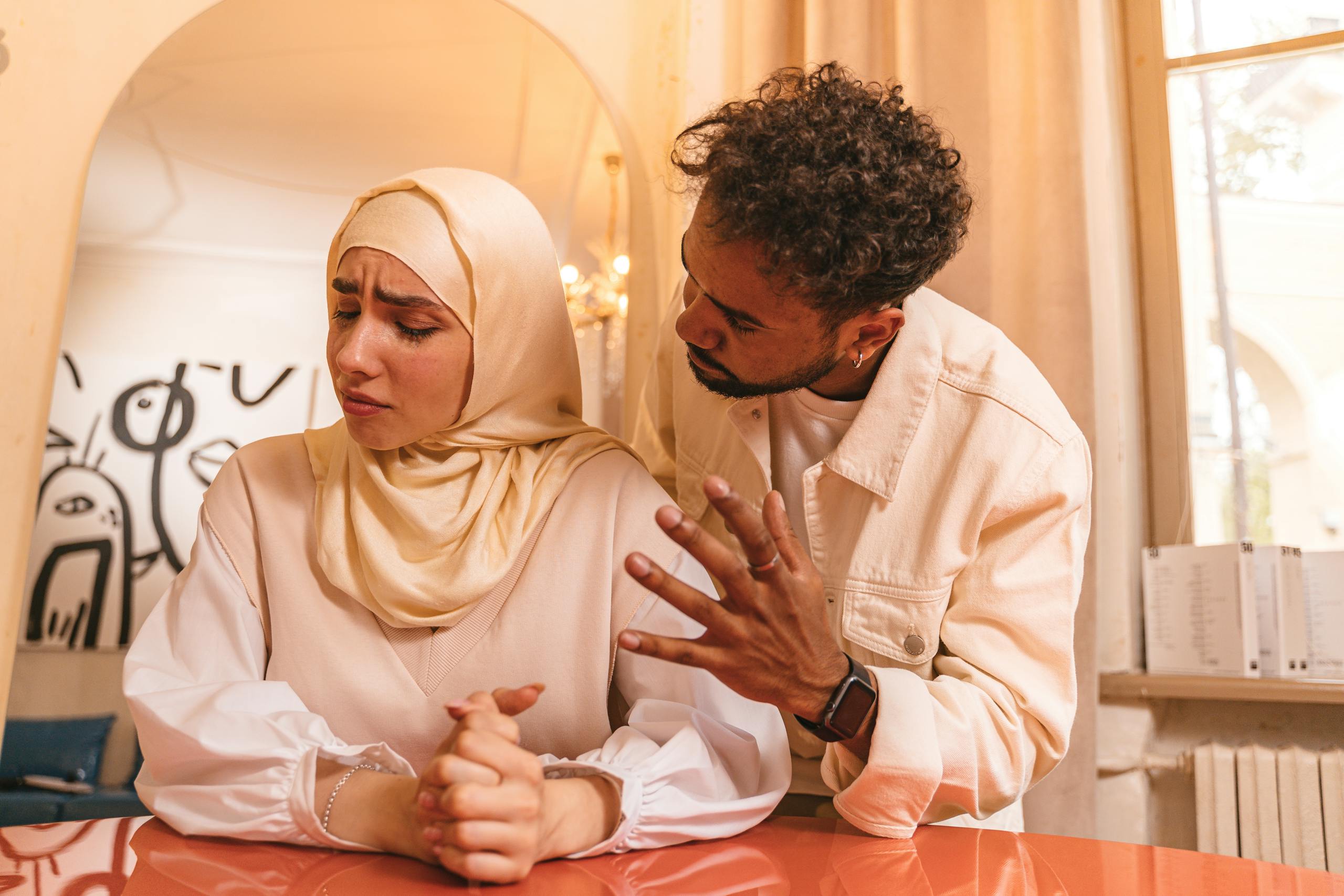 A tense moment between a man and woman indoors, highlighting relationship conflict.