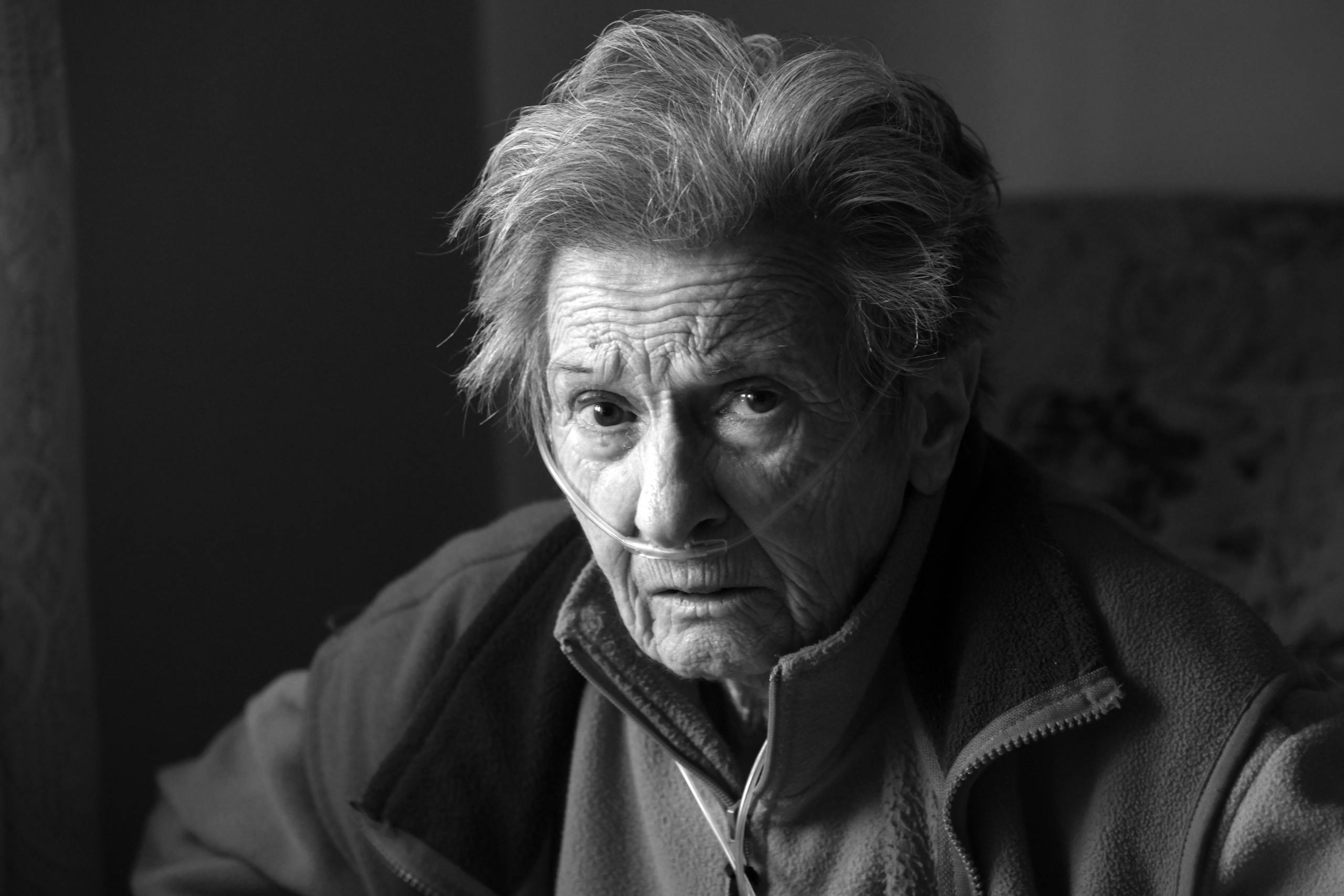 A touching portrait of an elderly woman using oxygen support, showing resilience and strength.
