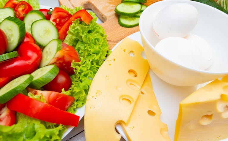 A vibrant platter of fresh salad, cheese slices, and eggs, ideal for healthy meals.