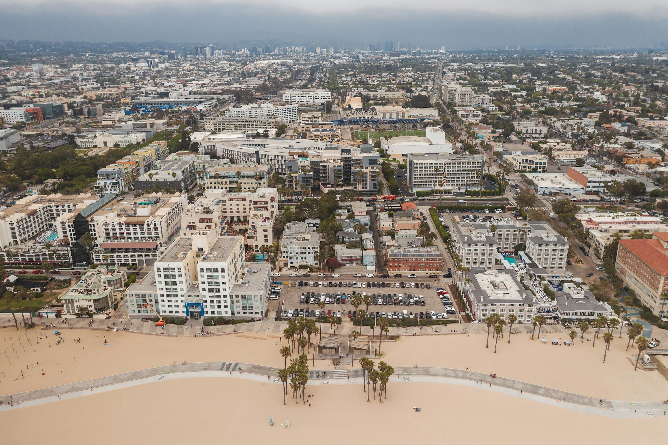 Aerial shot of Venice Beach with Los Angeles skyline, showcasing urban and coastal landscape.