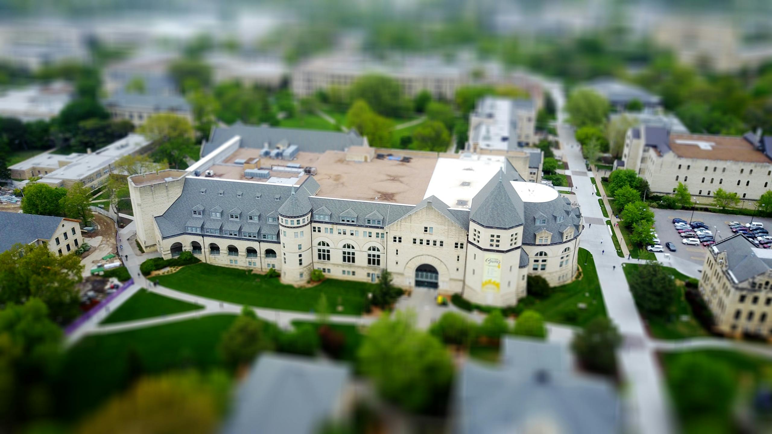 Aerial view of a university campus in Manhattan, Kansas, showcasing modern architecture and lush greenery.