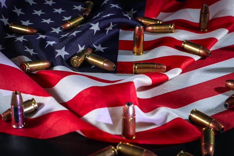 American flag draped with bullets, symbolizing patriotism and force.