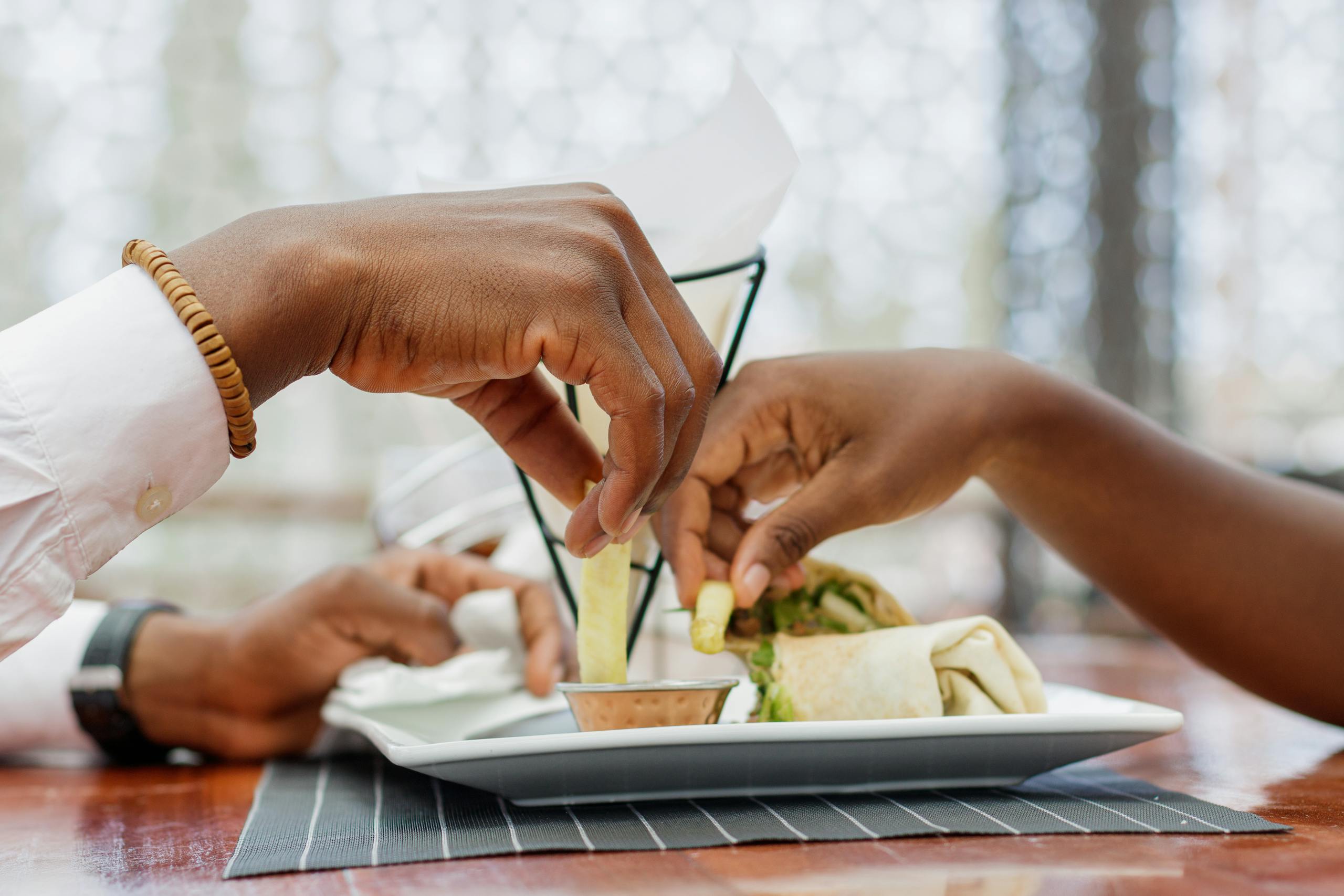 Close-up of a couple sharing food at a restaurant in Accra, Ghana. Intimate and casual dining scene.