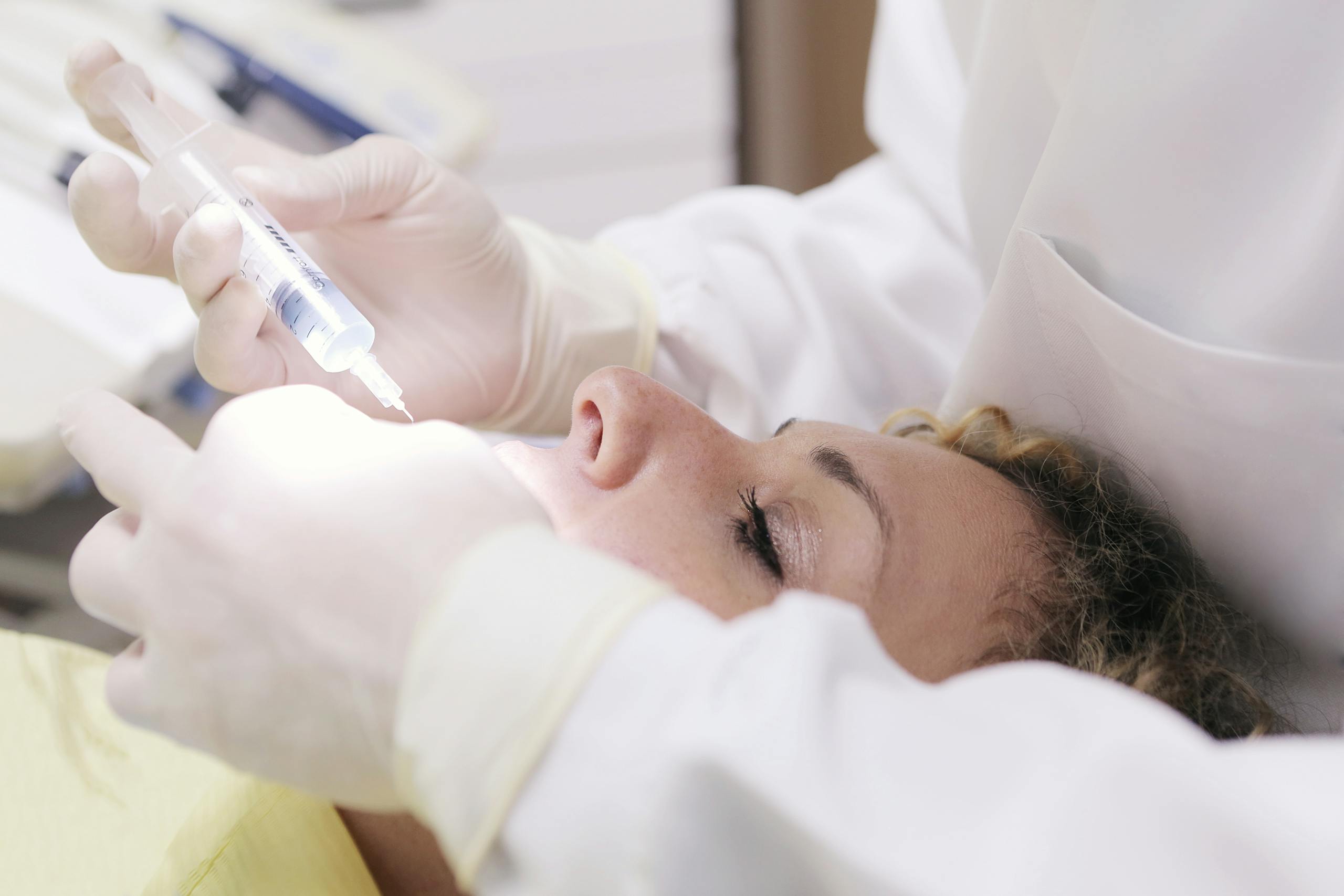 Close-up of a dental professional administering an anesthetic injection to a patient in a clinic.