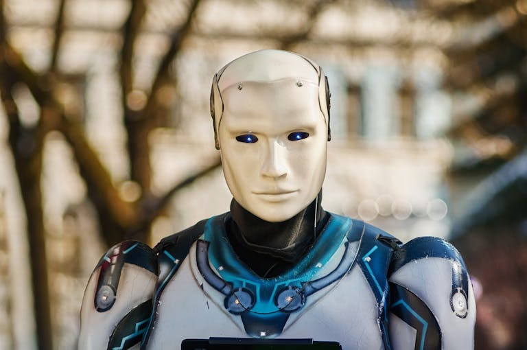 Close-up of a humanoid robot with a futuristic design posing outdoors.
