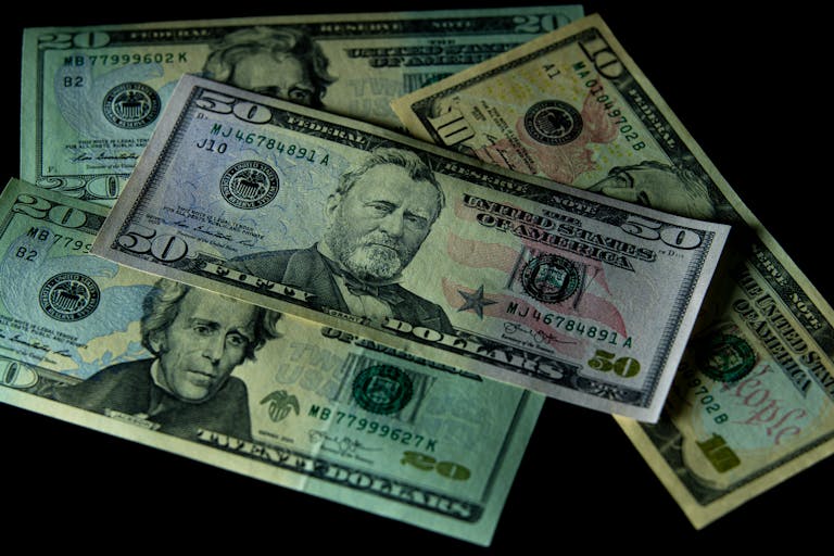 Close-up of assorted US dollar bills isolated on a black background.