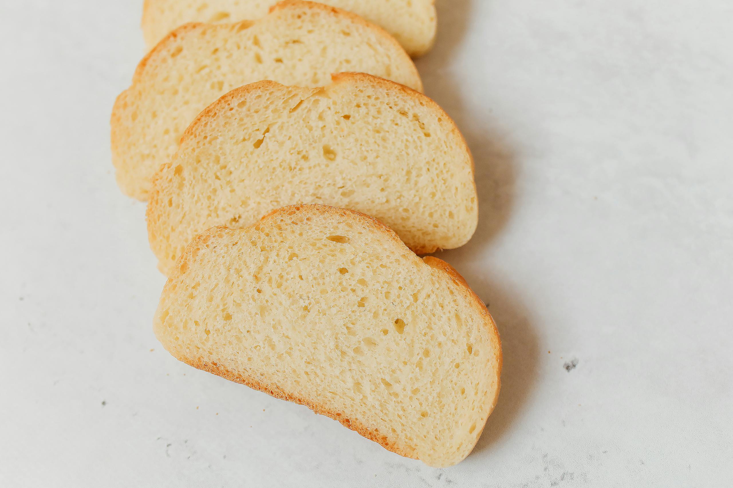 Close-up of freshly sliced white bread showcasing its soft texture on a bright surface.
