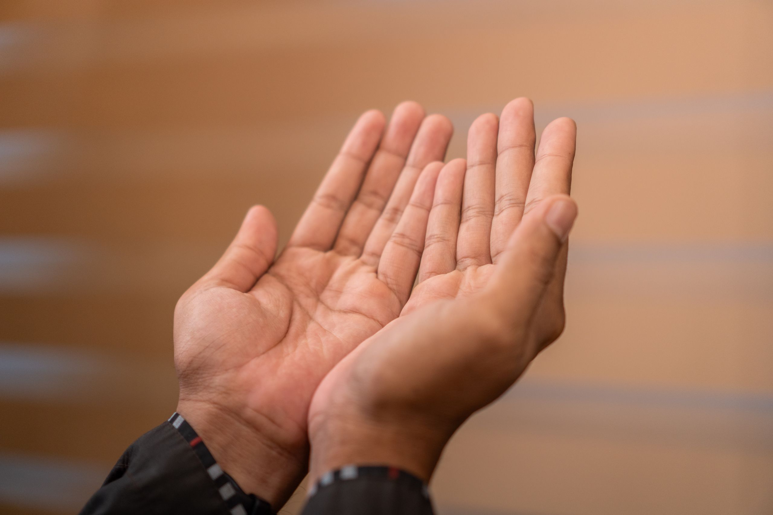 Close-up of hands in prayer gesture, symbolizing Islamic devotion. Captured indoors in Sulawesi Selatan, Indonesia.