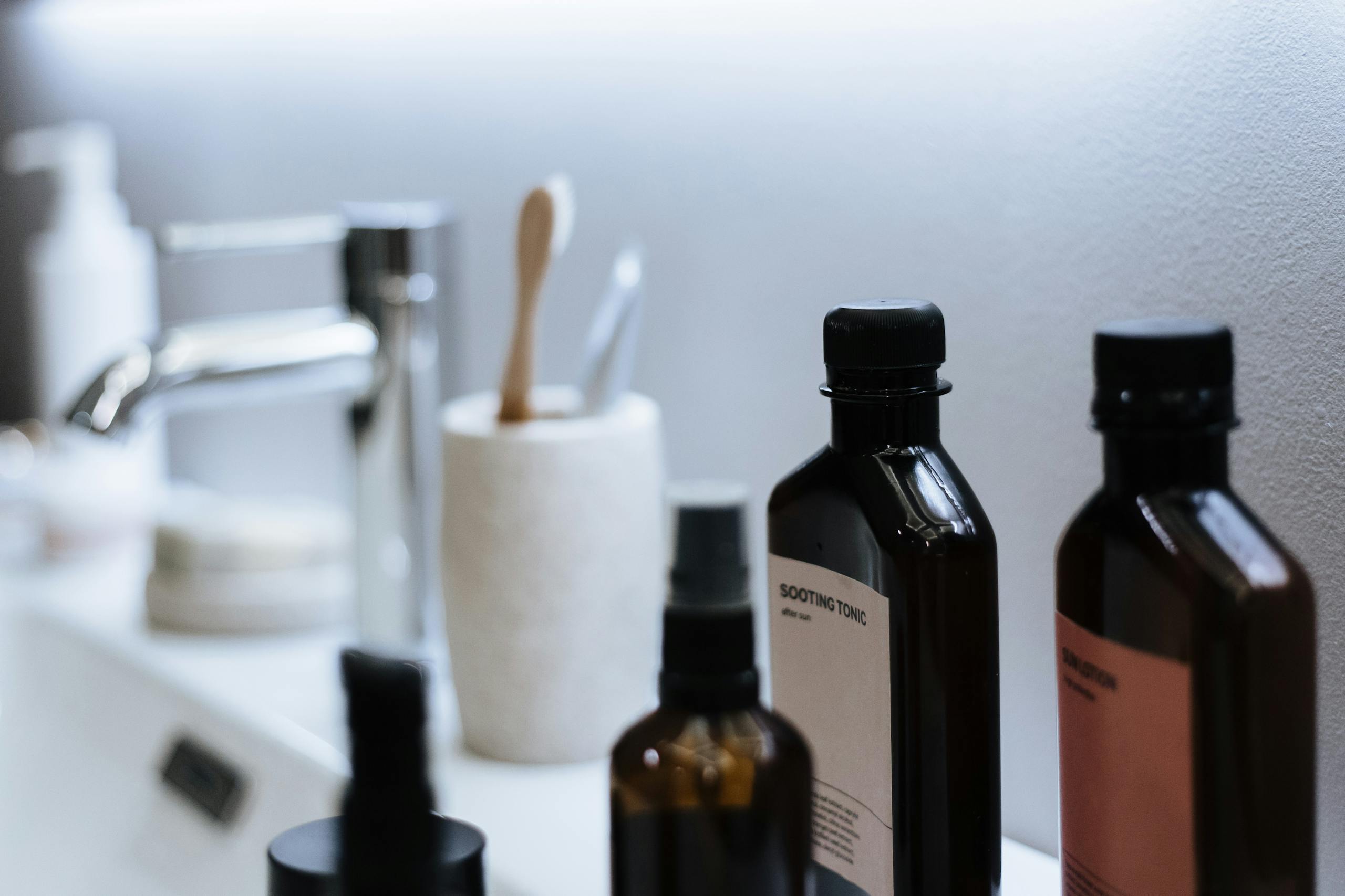 Close-up of modern bathroom sink counter with essential cosmetic products, offering stylish organization.