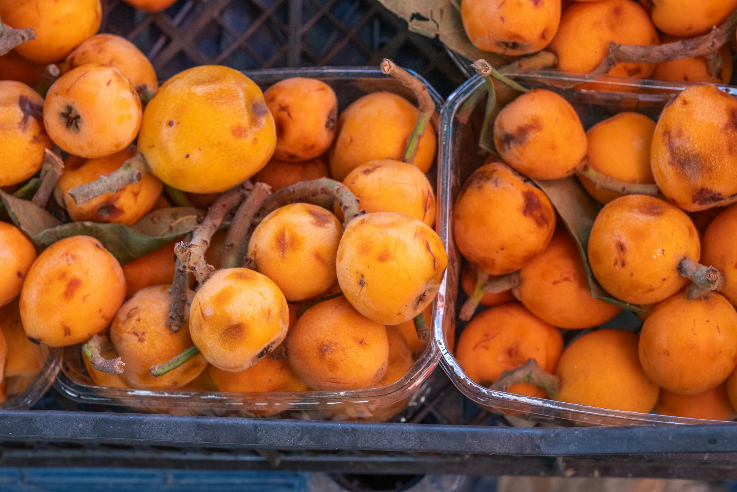 Close-up of ripe loquats displayed at a market in Bornova, İzmir, Türkiye.