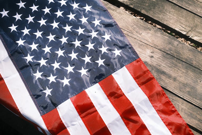 Close-up of the American flag draped over a rustic wooden surface, highlighting the stars and stripes.
