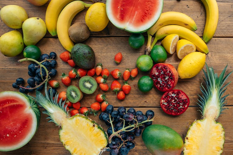 Colorful array of sliced and whole tropical fruits on a wooden background. Perfect for food and health concepts.