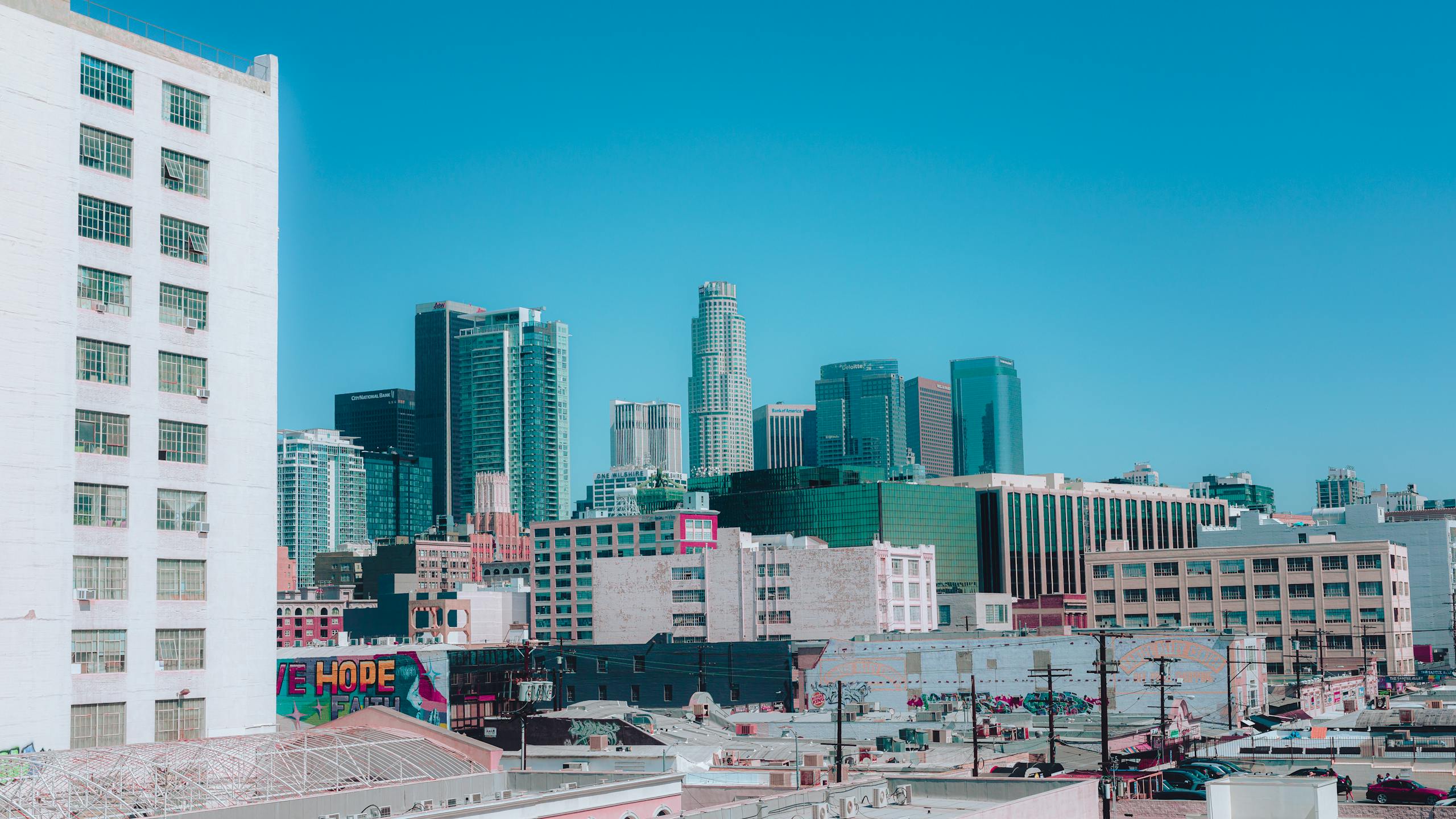 Colorful view of Los Angeles skyline under a clear blue sky, capturing urban life.