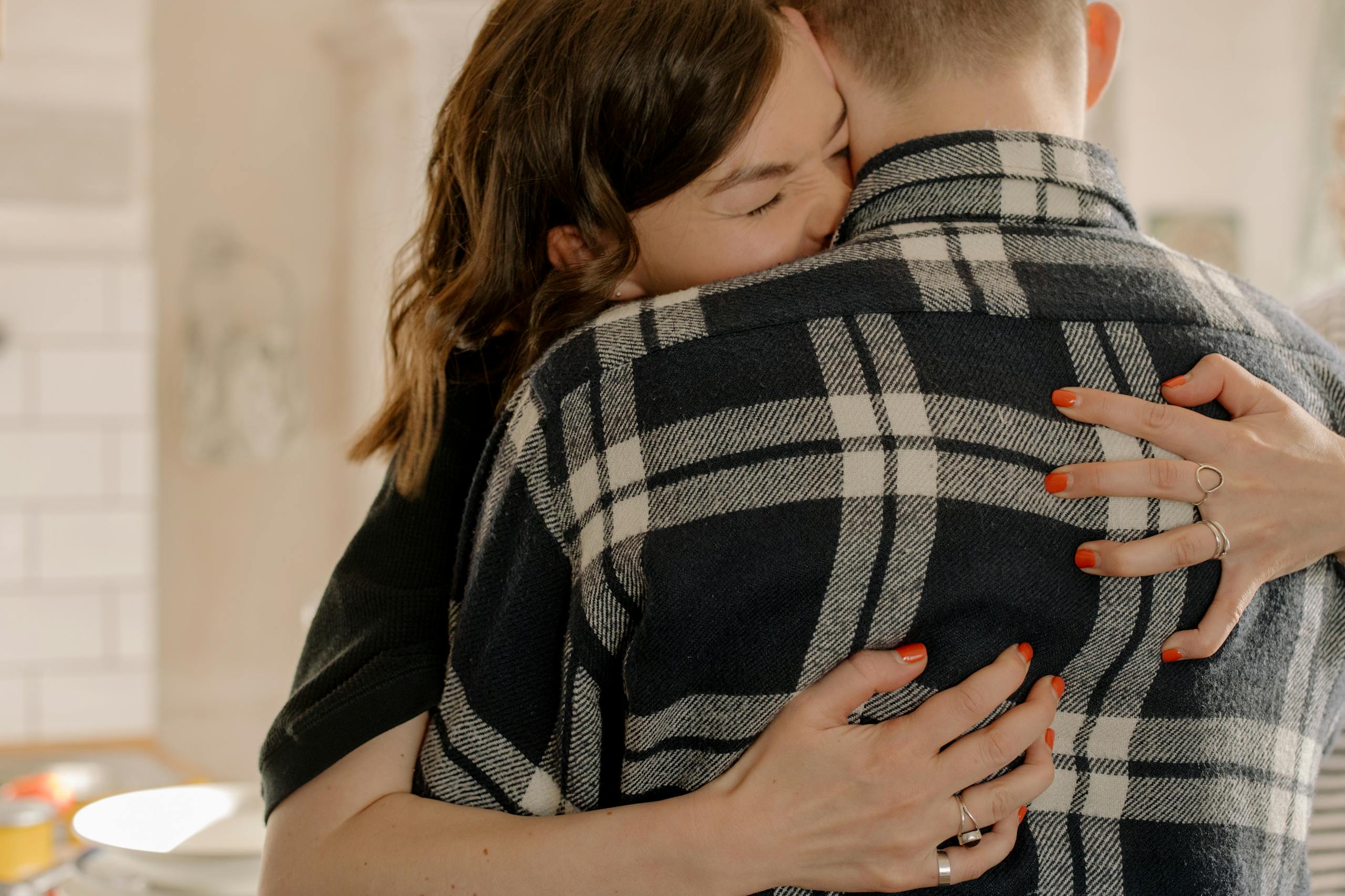 Couple embracing warmly indoors, expressing love and connection.
