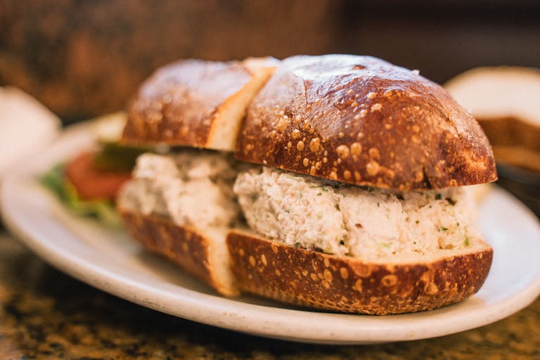 Delicious crab salad sandwich served on a ceramic plate, perfect for seafood lovers.