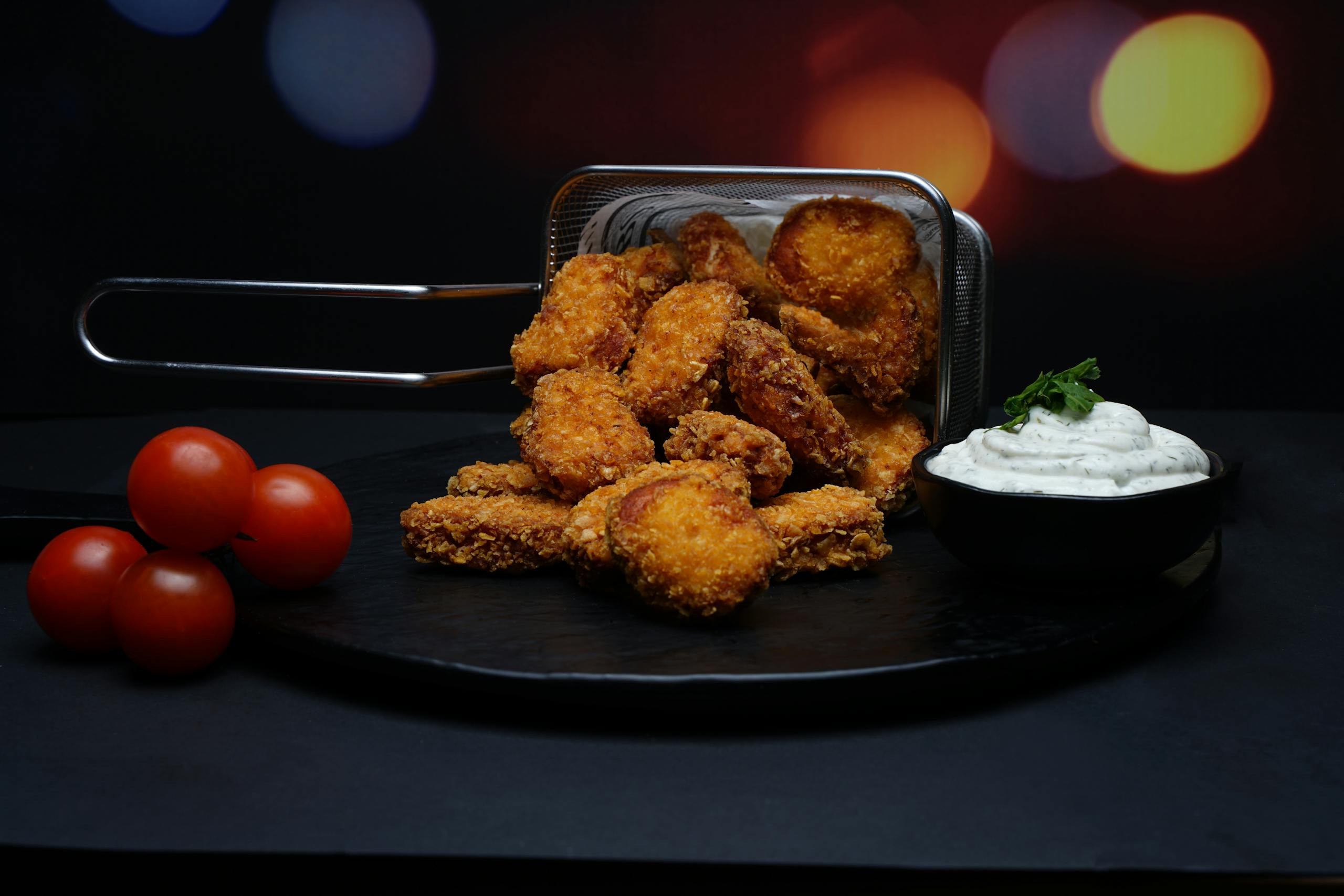 Delicious crispy nuggets served with fresh cherry tomatoes and a side of creamy dipping sauce.