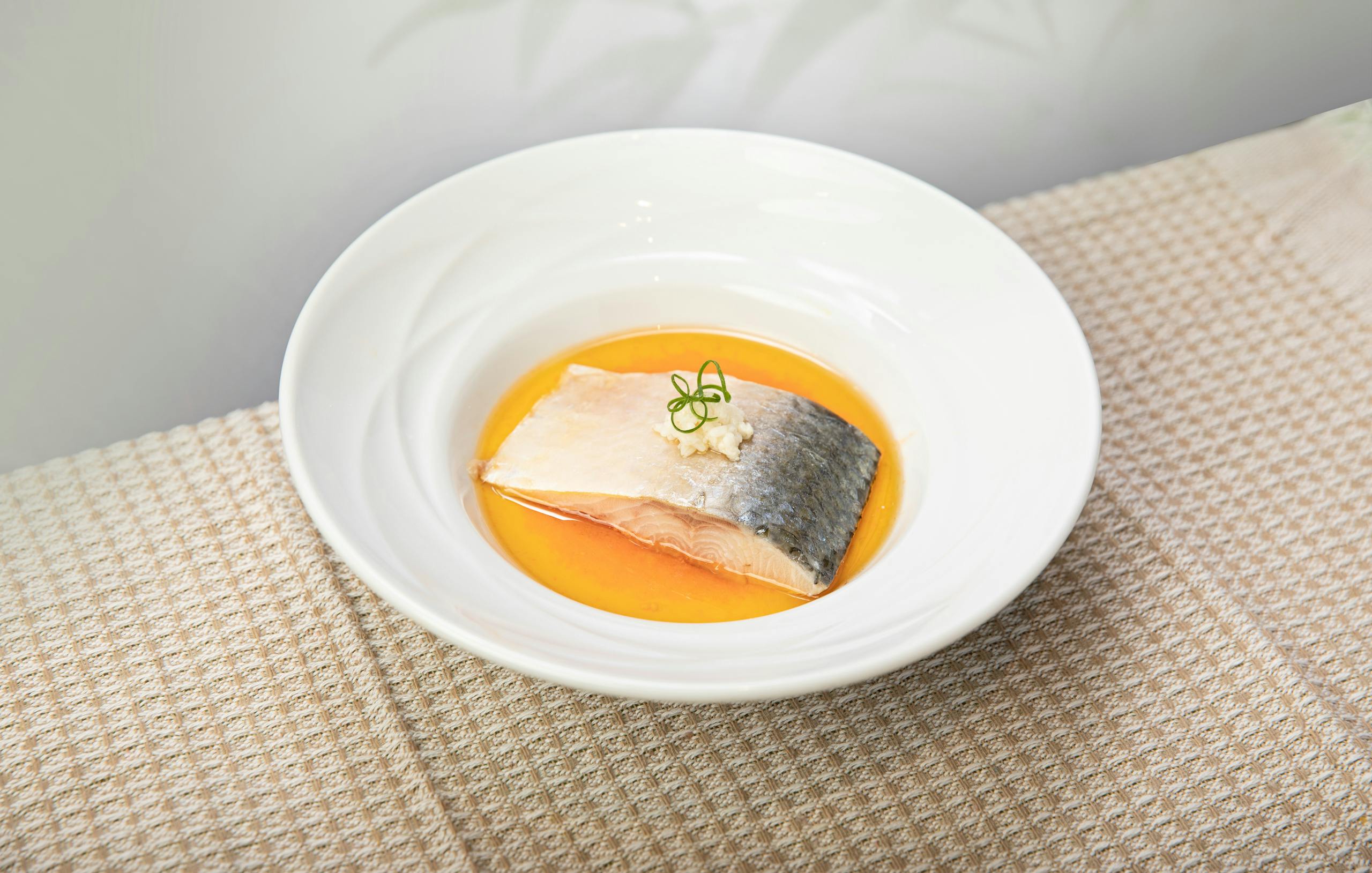 Delicious salmon served in a vibrant orange sauce with garnish.
