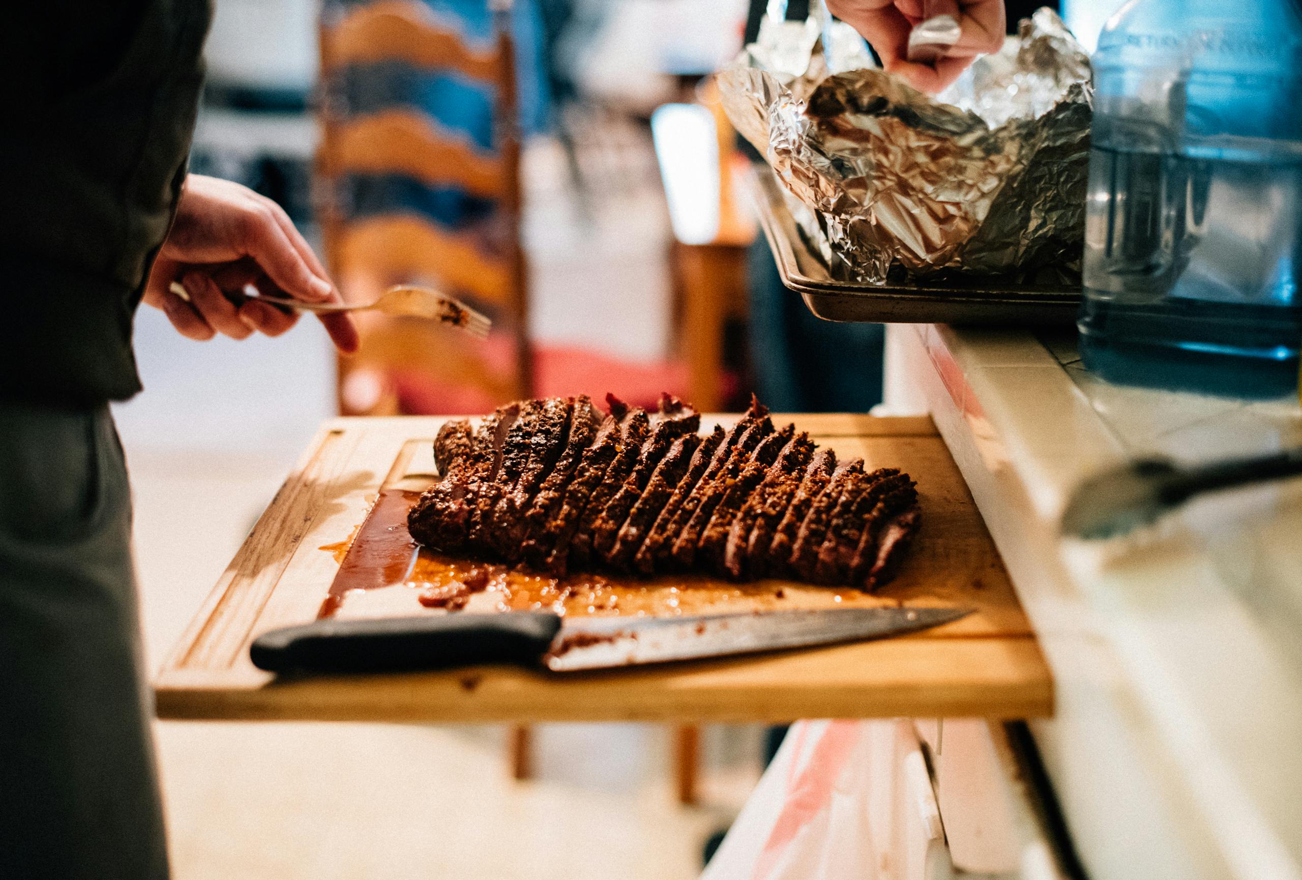 Delicious sliced brisket on a wooden board, perfect for a cozy indoor meal.