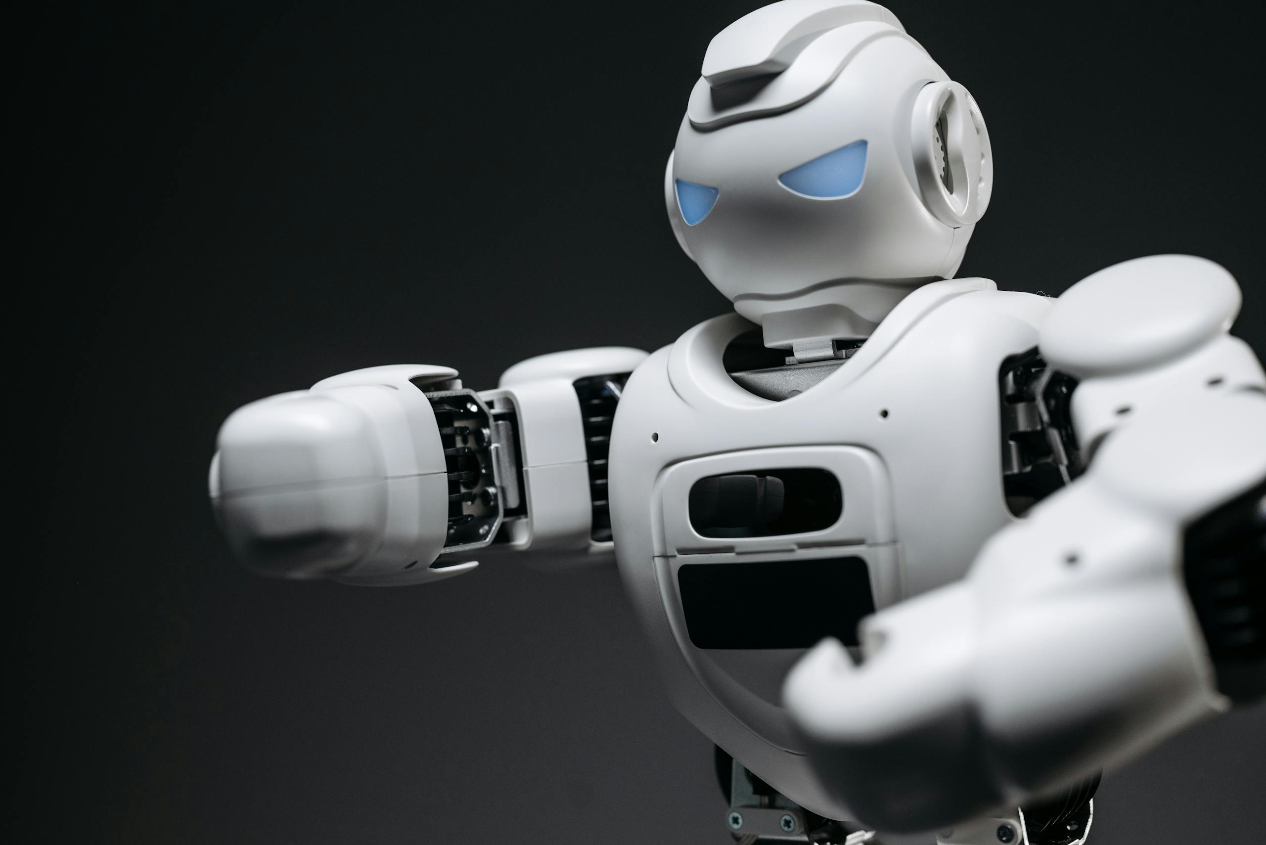 Detailed close-up of a high-tech white robot in a studio setting with a gray background.