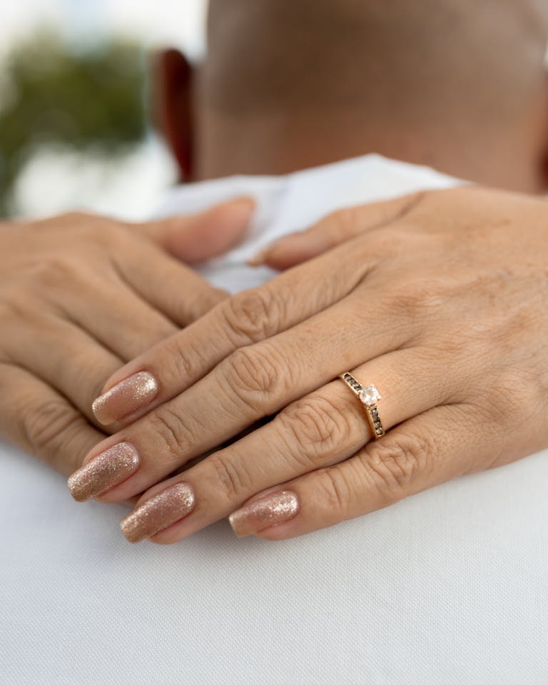 Elegant close-up of a woman's hands showing an engagement ring outdoors, perfect for wedding themes.