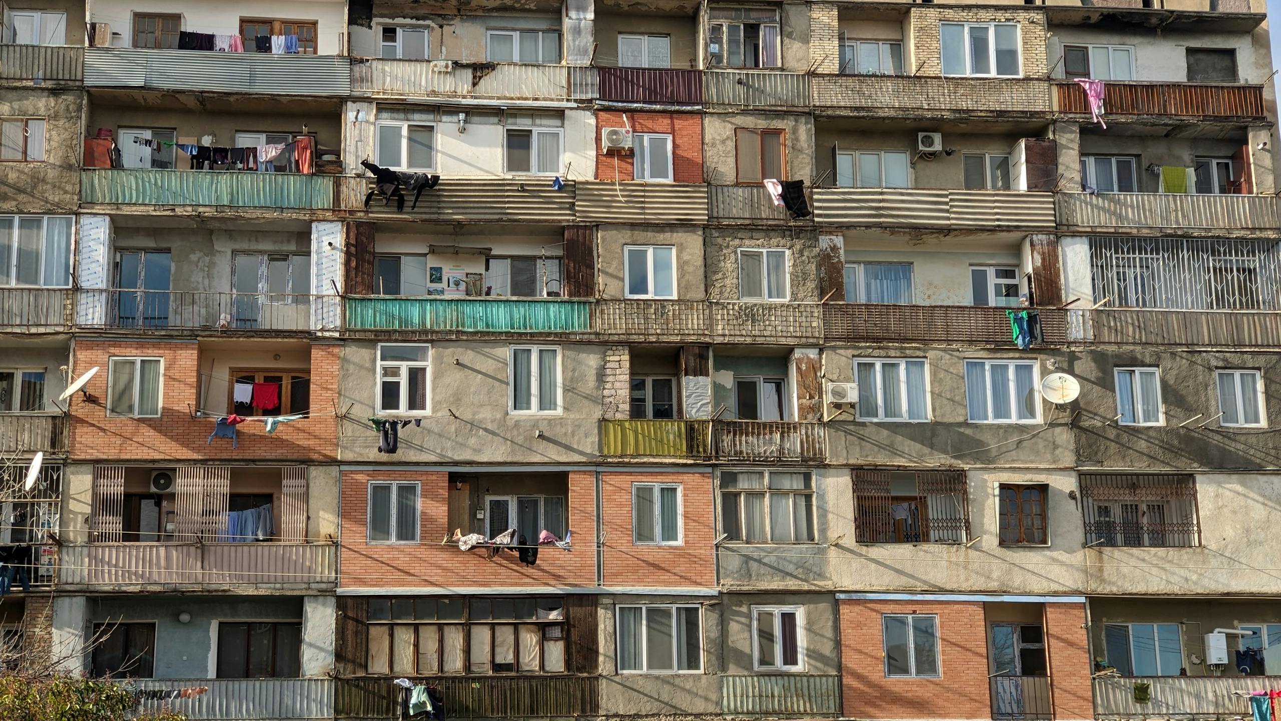 Exterior view of a multi-story apartment building in Rustavi, showcasing varied architecture and balconies.