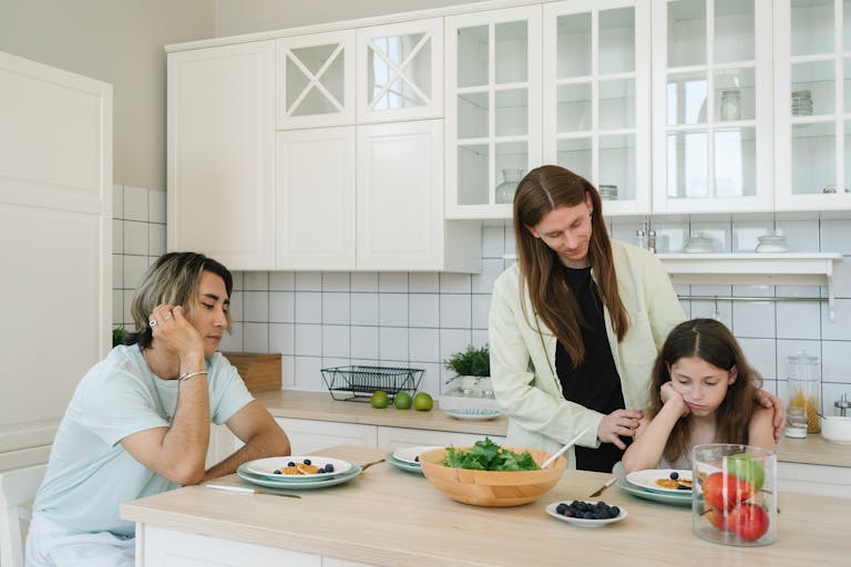 Family sitting around the kitchen table, sharing a meal in a modern setting.