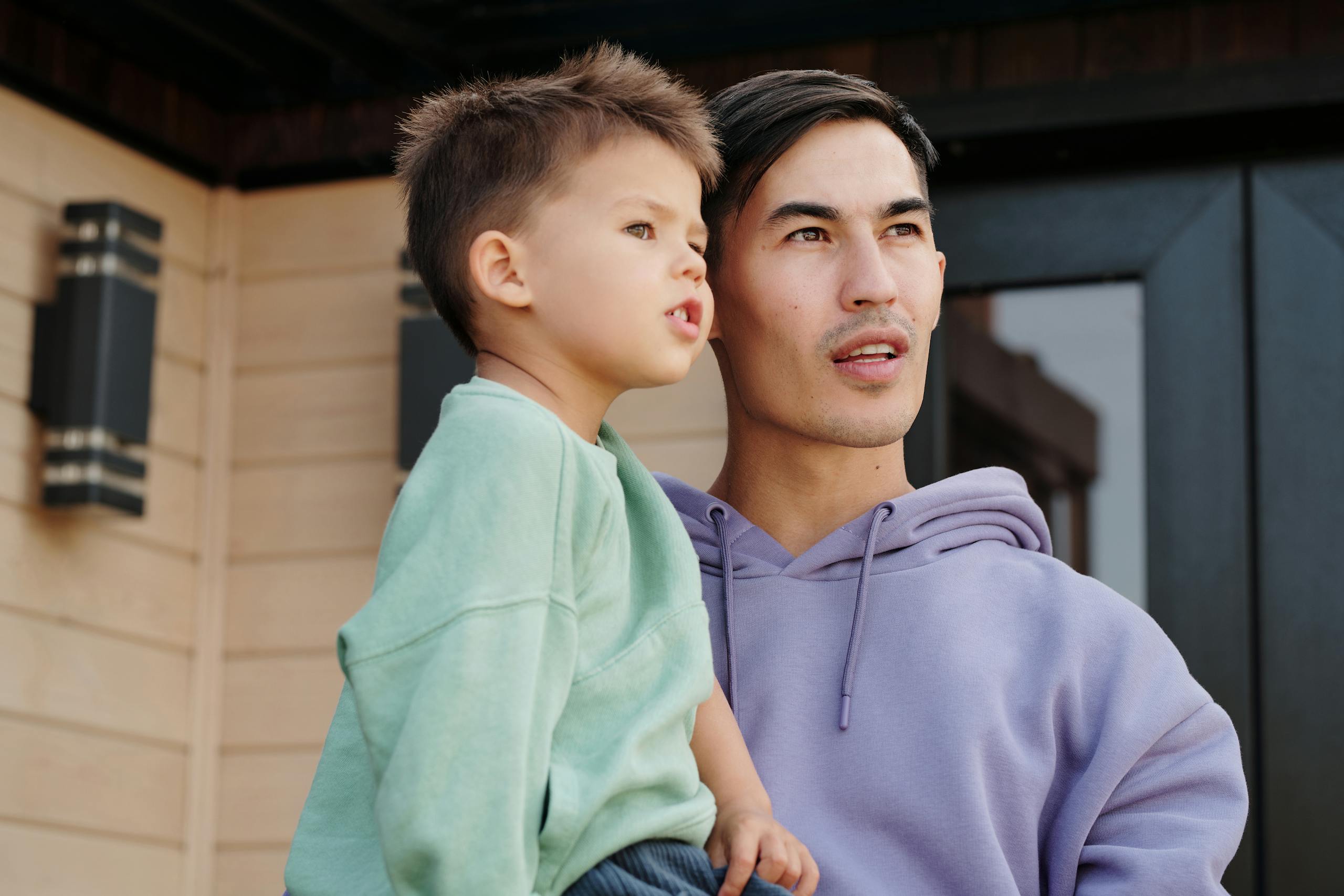 Father and son looking into the distance while enjoying a moment together outside.