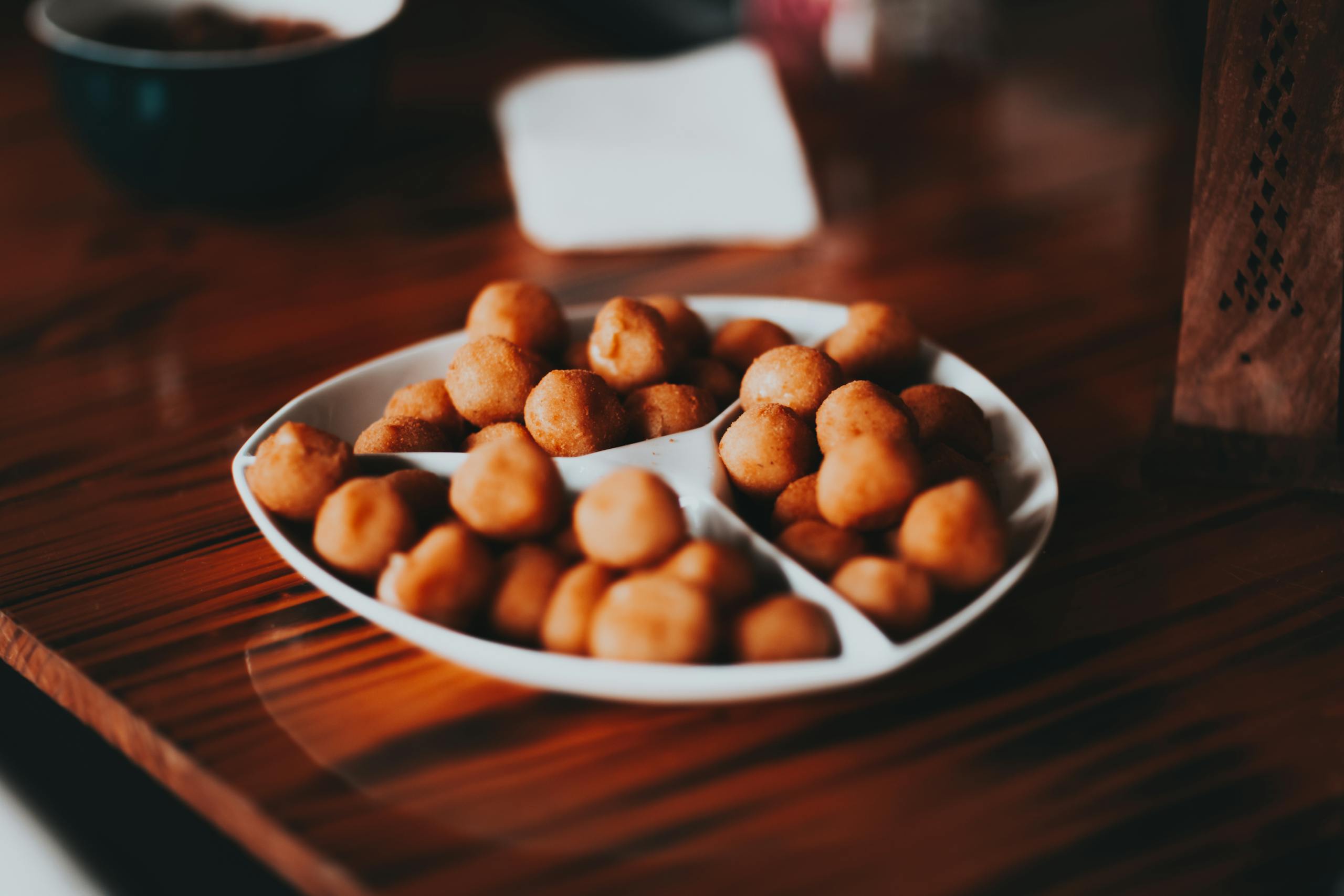 From above of plate with delicious crispy roasted salty nuts placed on wooden table