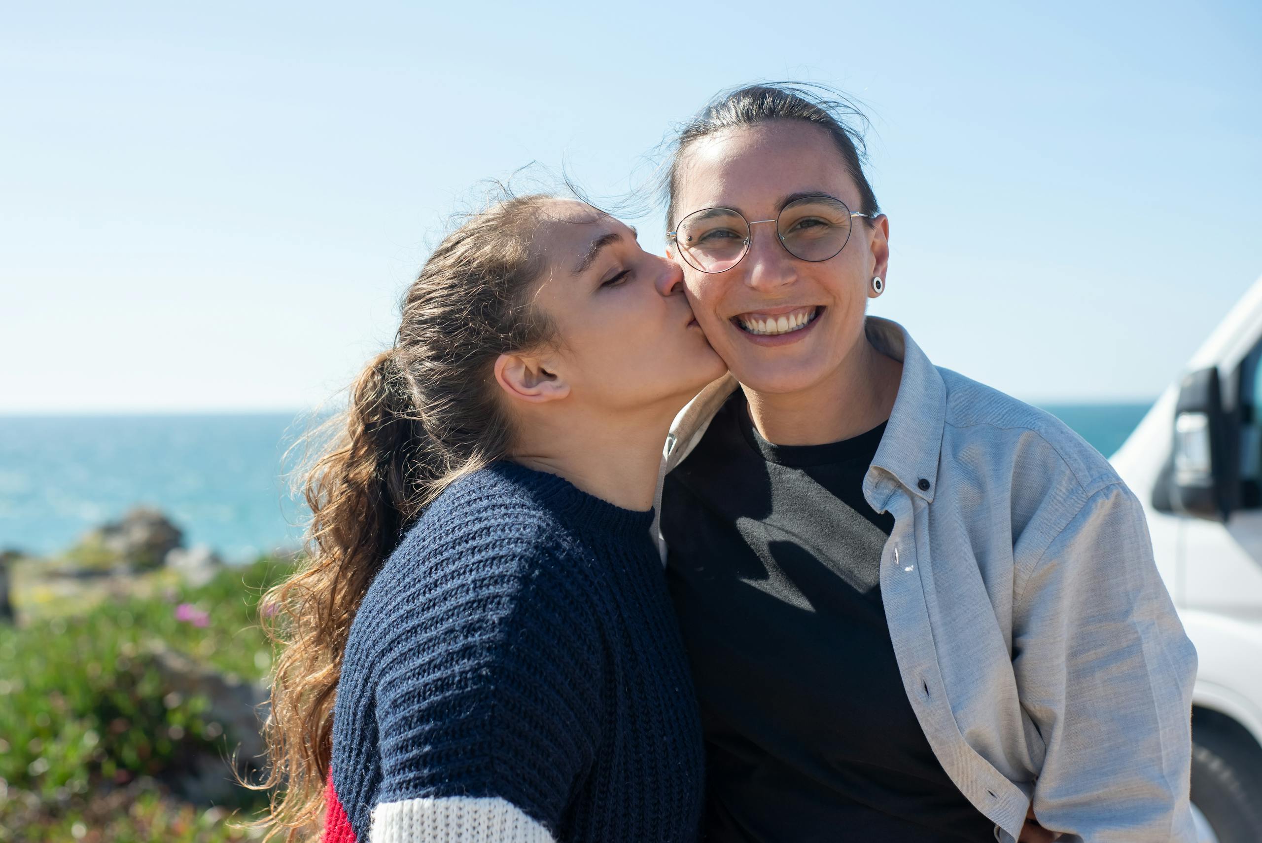 Happy couple in love embracing by the coastline in Portugal, showcasing affection and joy.