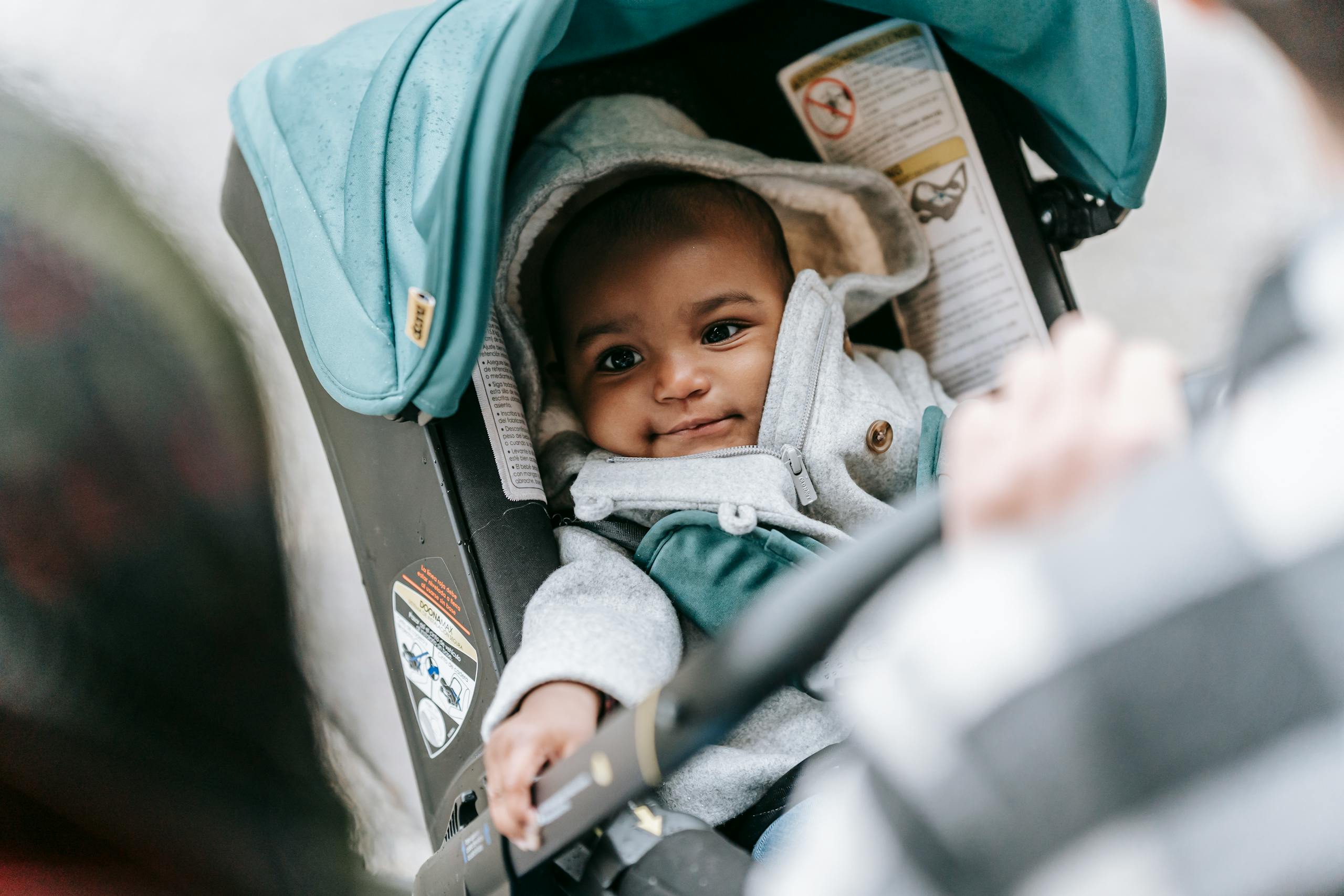 High angle of crop parents with little infants in stroller during walk on street
