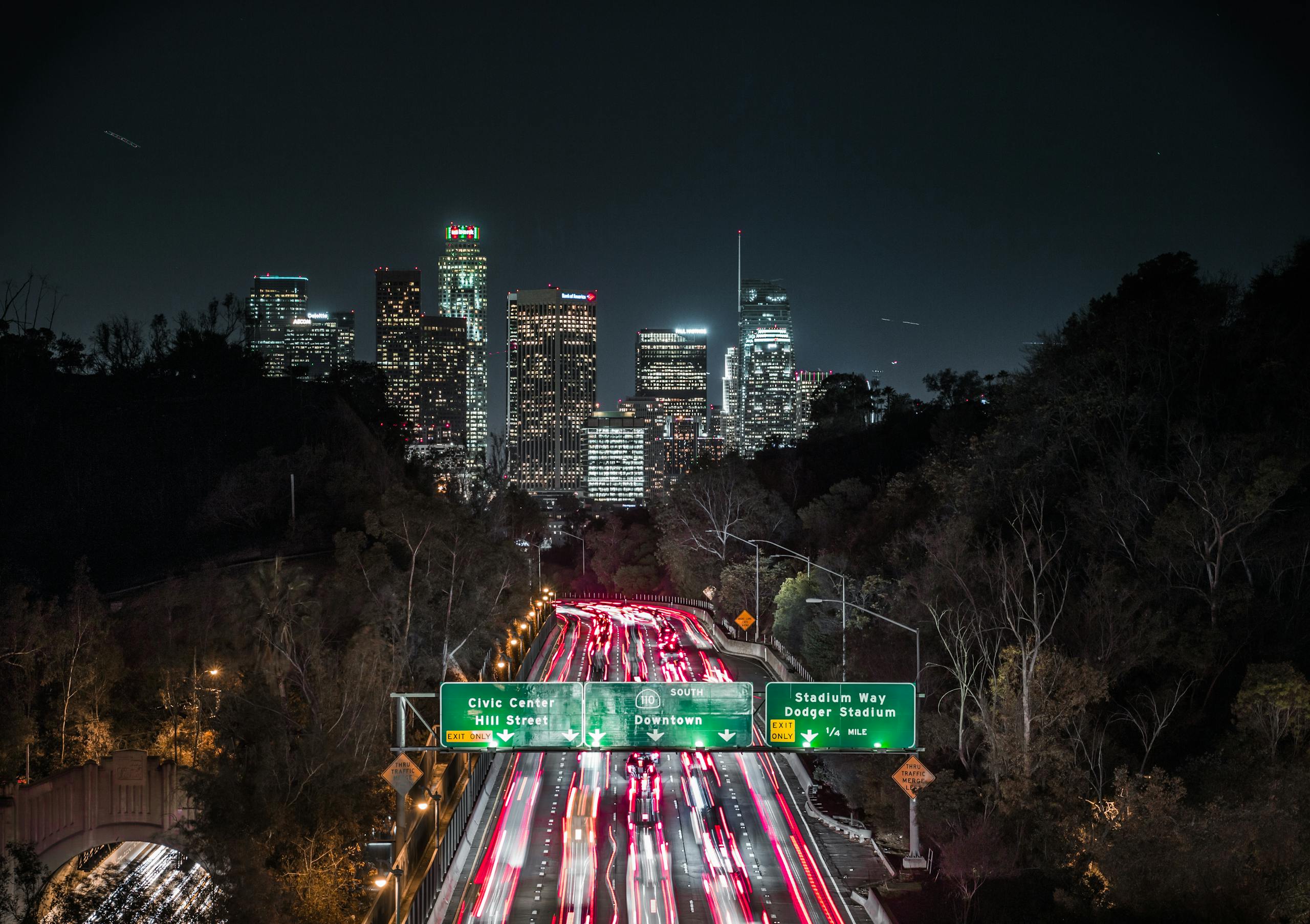 Long exposure of LA traffic with illuminated downtown skyline in view.