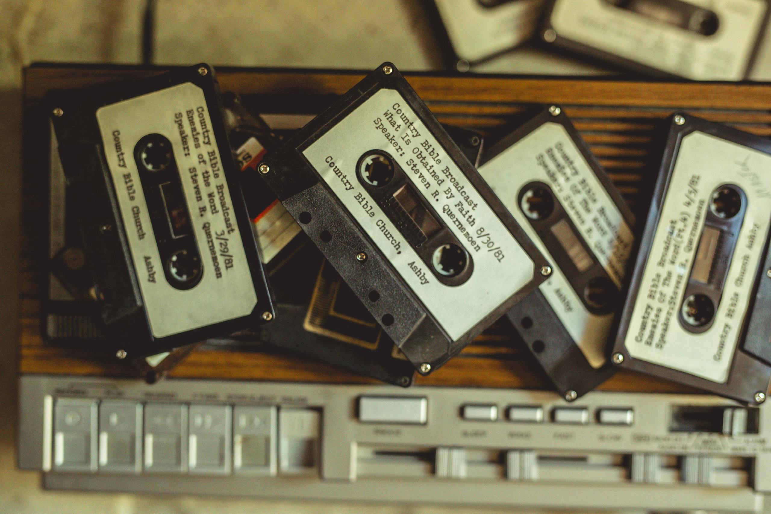 Pile of vintage cassette tapes on a classic audio player, evoking nostalgia and vintage charm.