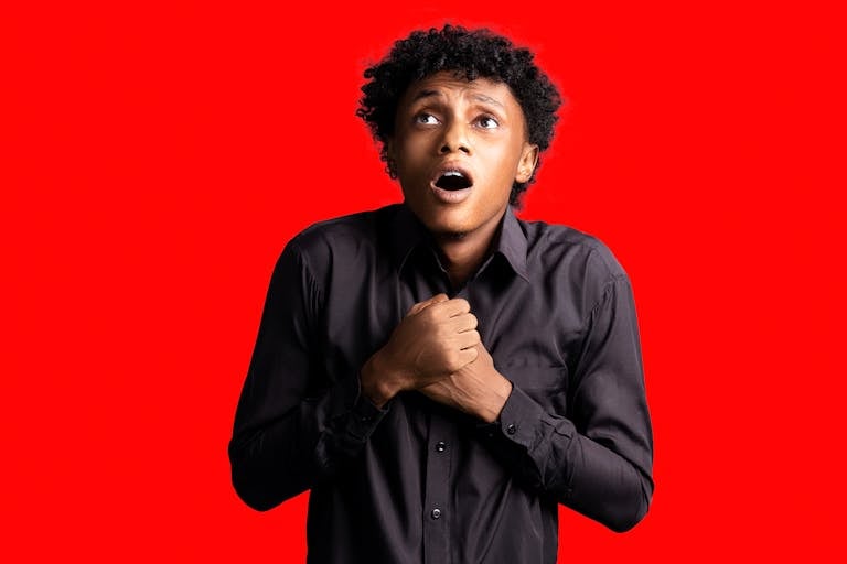 Portrait of a frightened man with open mouth on a red background.