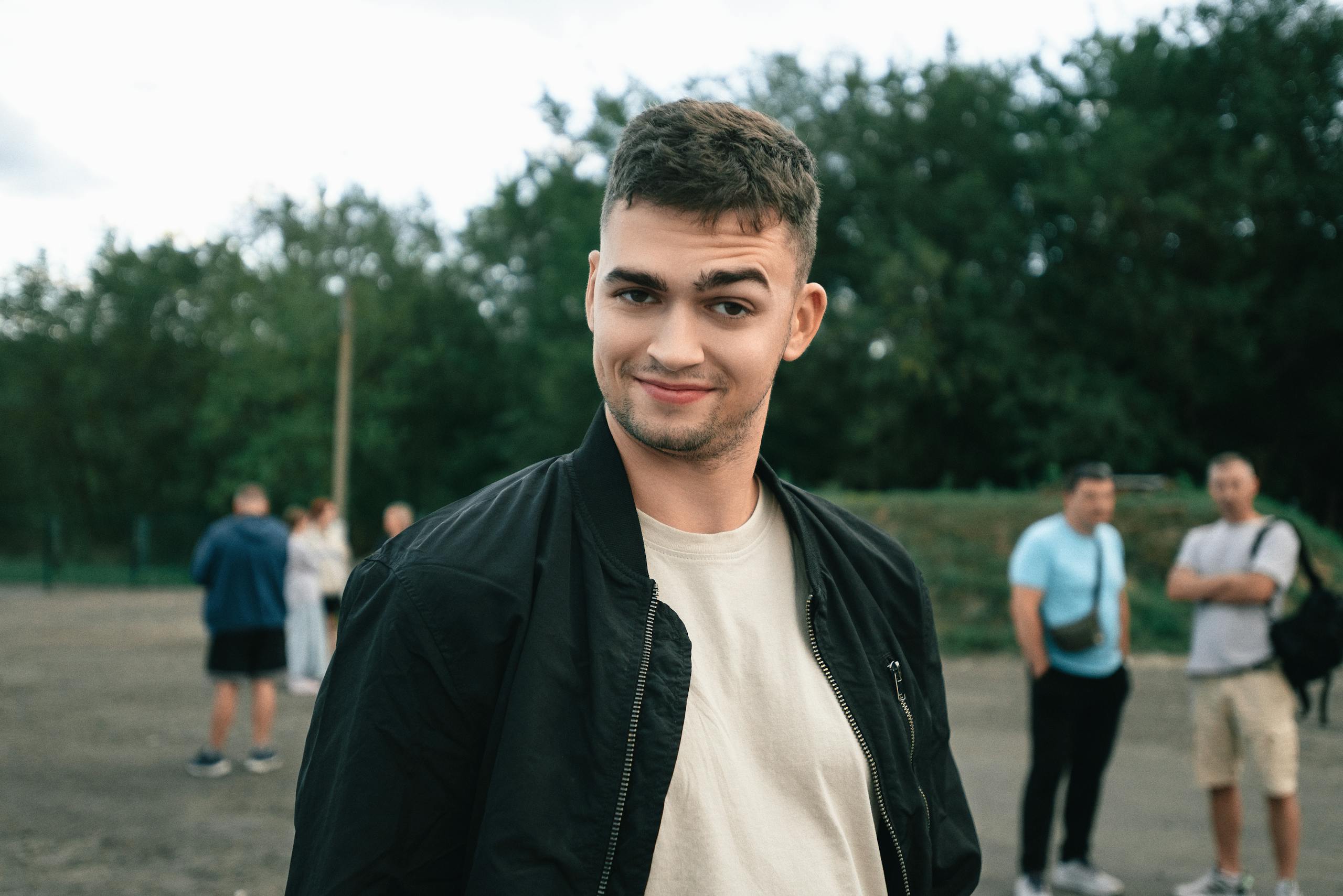 Portrait of a young man outdoors, embracing casual fashion in a summer setting.